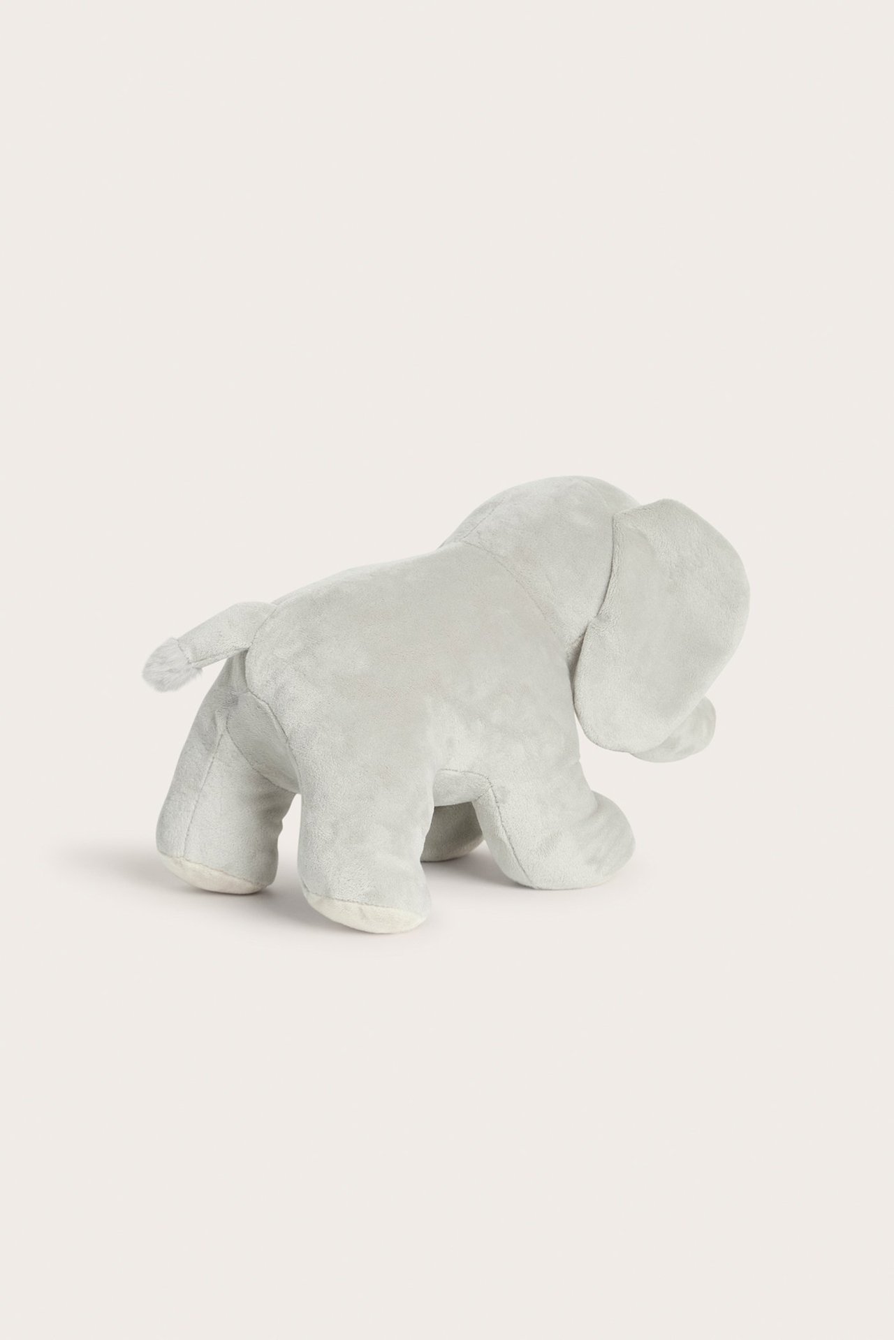 Sidovy av en ljusgrå mjuk elefant gosedjur.