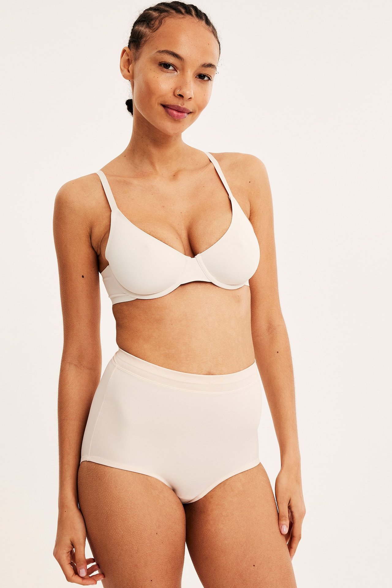 Frontbilde av en kvinne i beige høy midje shaping hipster og matchende beige BH.