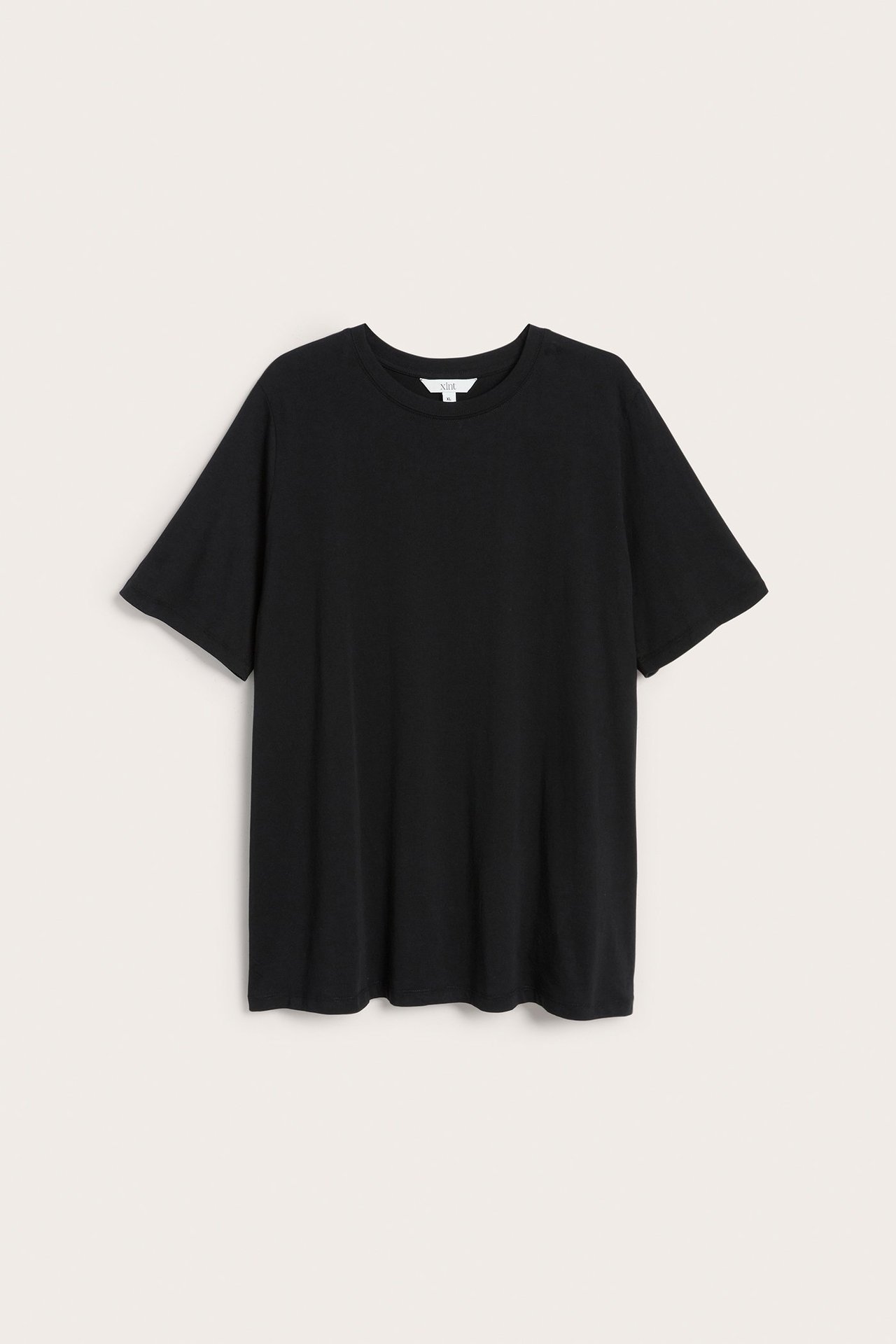 Framsida av en svart, enfärgad, lös, lång t-shirt-tunika i bomull med korta ärmar.