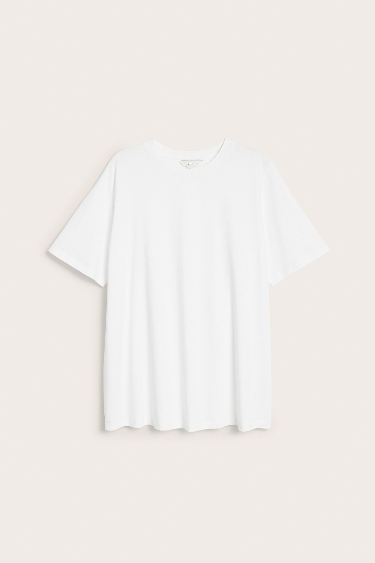 Hvit, løstsittende, lang bomulls t-skjorte tunika med korte ermer og rund hals, sett forfra.