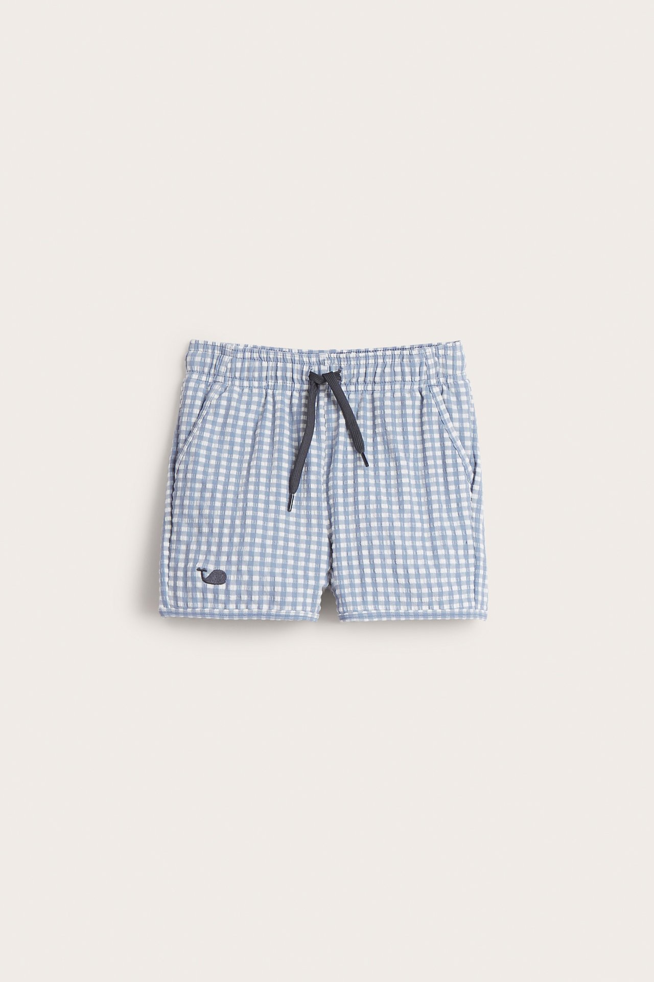 Frontvy av rutiga badshorts i blått och vitt seersucker med resår, mörk dragsko och valbrodyr.