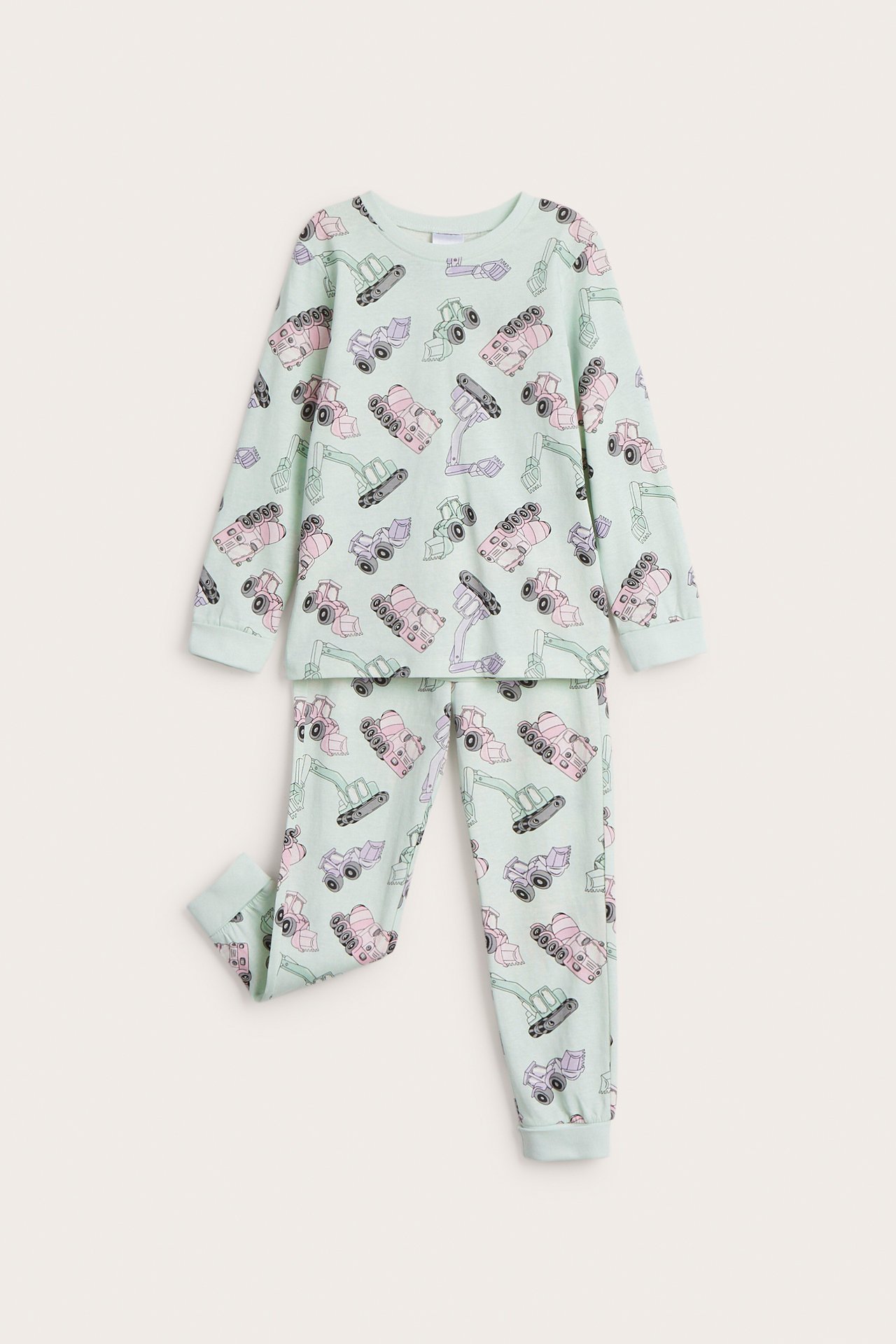 Framifrån, ett barns ljusgröna pyjamas i bomull med lång ärm och heltäckande fordonstryck.