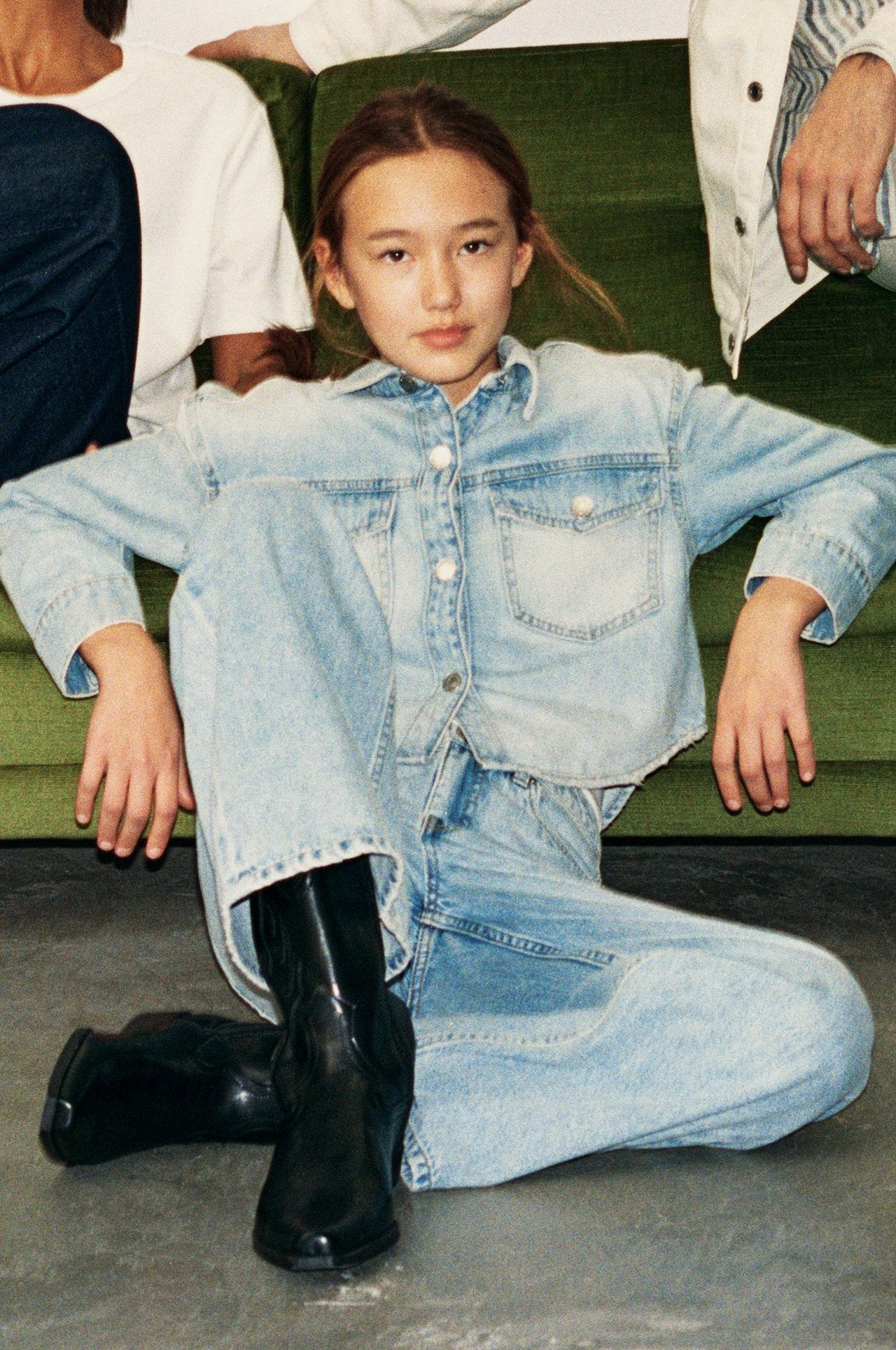 Edestä: Lapsi yllään vaalea denim-paitatakki, yhteensopivat leveälahkeiset farkut ja mustat cowboy-saappaat.