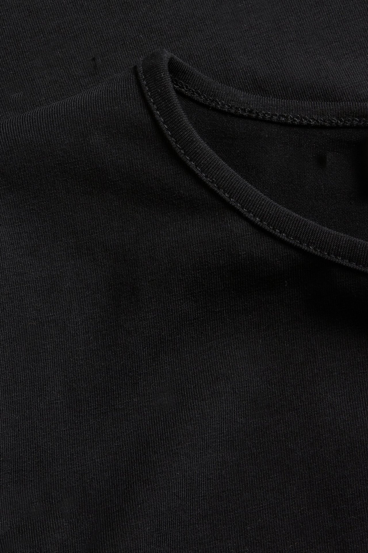 Zbliżenie czarnej bluzki z długim rękawem z bawełnianej dzianiny z okrągłym dekoltem.