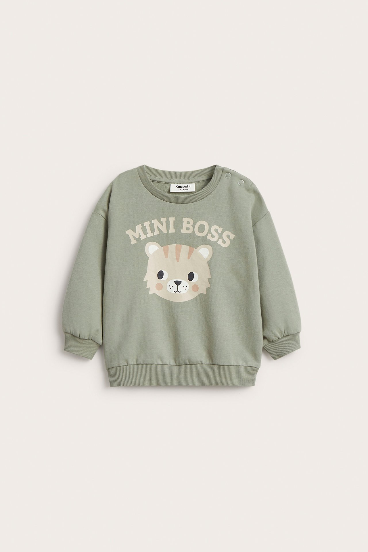 Edestä näkymä vauvan tummanvihreästä puuvillapaidasta, jossa 'MINI BOSS' ja tiikerikasvoprintti, olkapäässä nepparit.