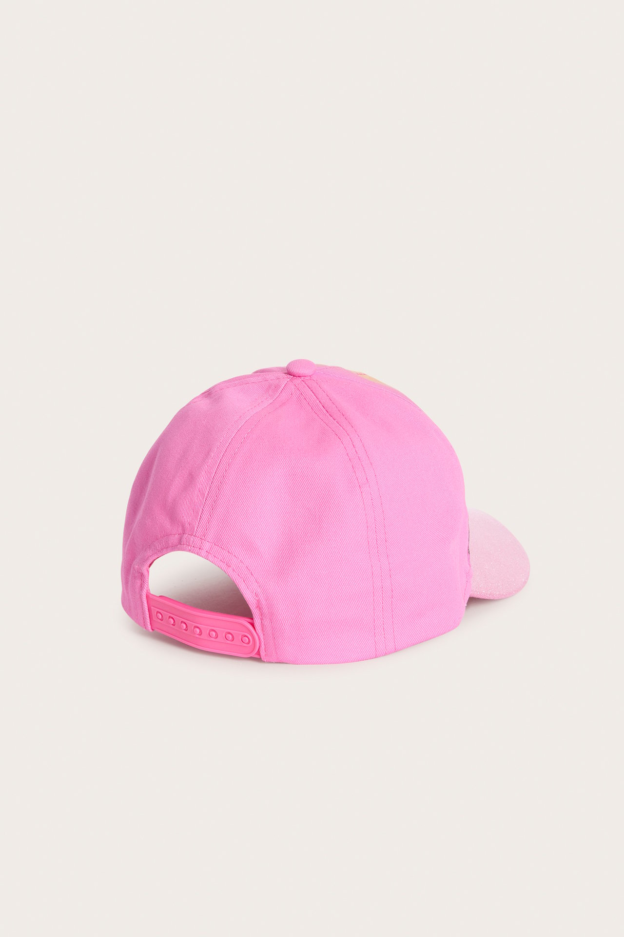 Baksida av en rosa barnkeps med justerbart spänne och en ljusrosa glittrig skärm.