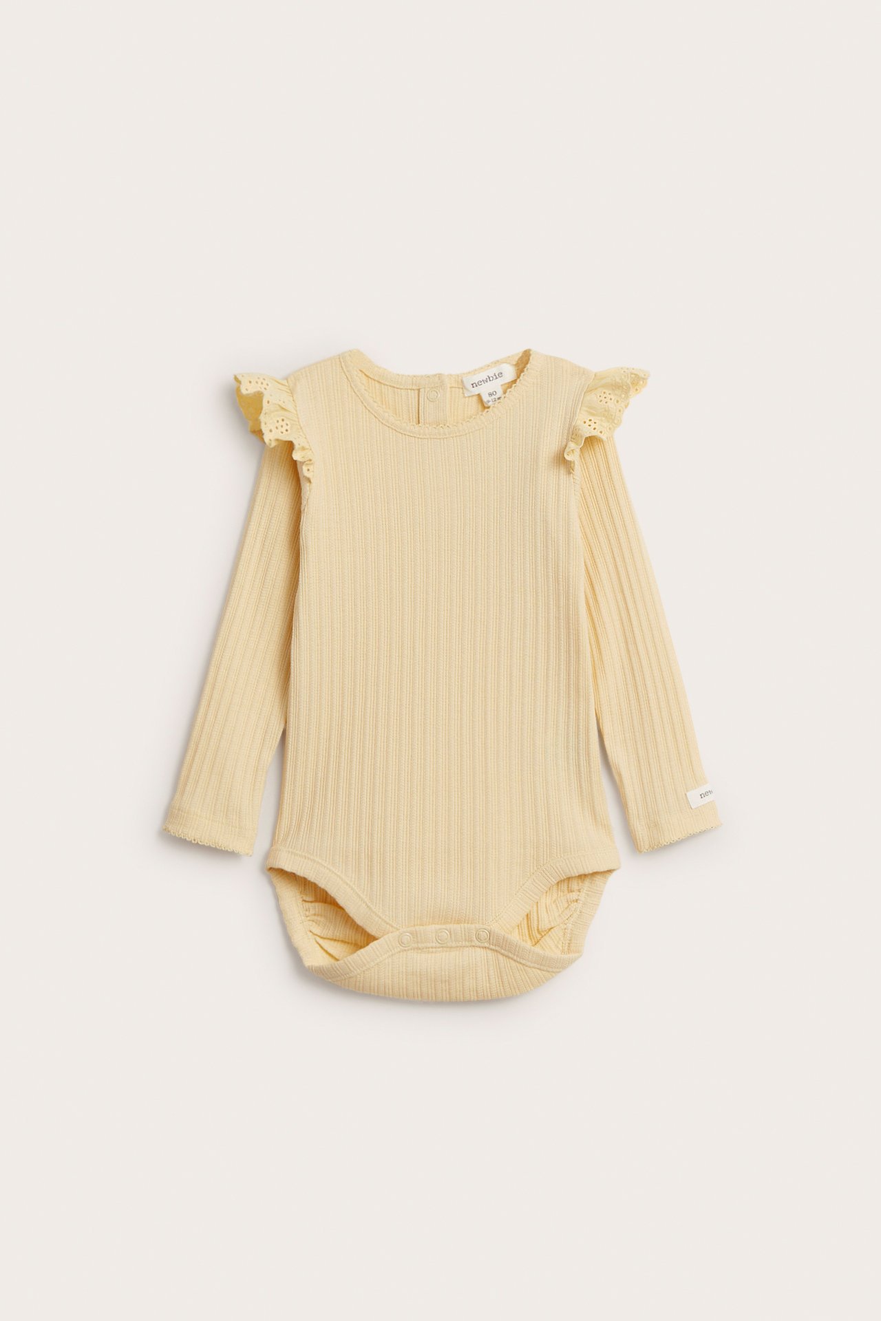 Frontvy av en gul ribbad långärmad babybody med volanger, spetsdetaljer på axlarna och tryckknappar.