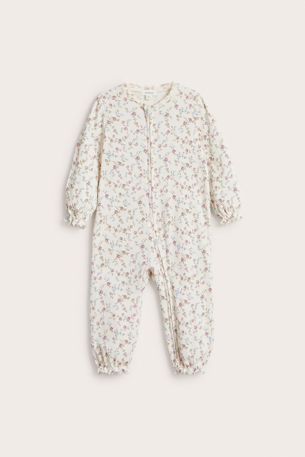 Edestä: Luonnonvalkoinen vauvan kukkakuvioinen ribbipuuvillapyjama kaksisuuntaisella vetoketjulla.