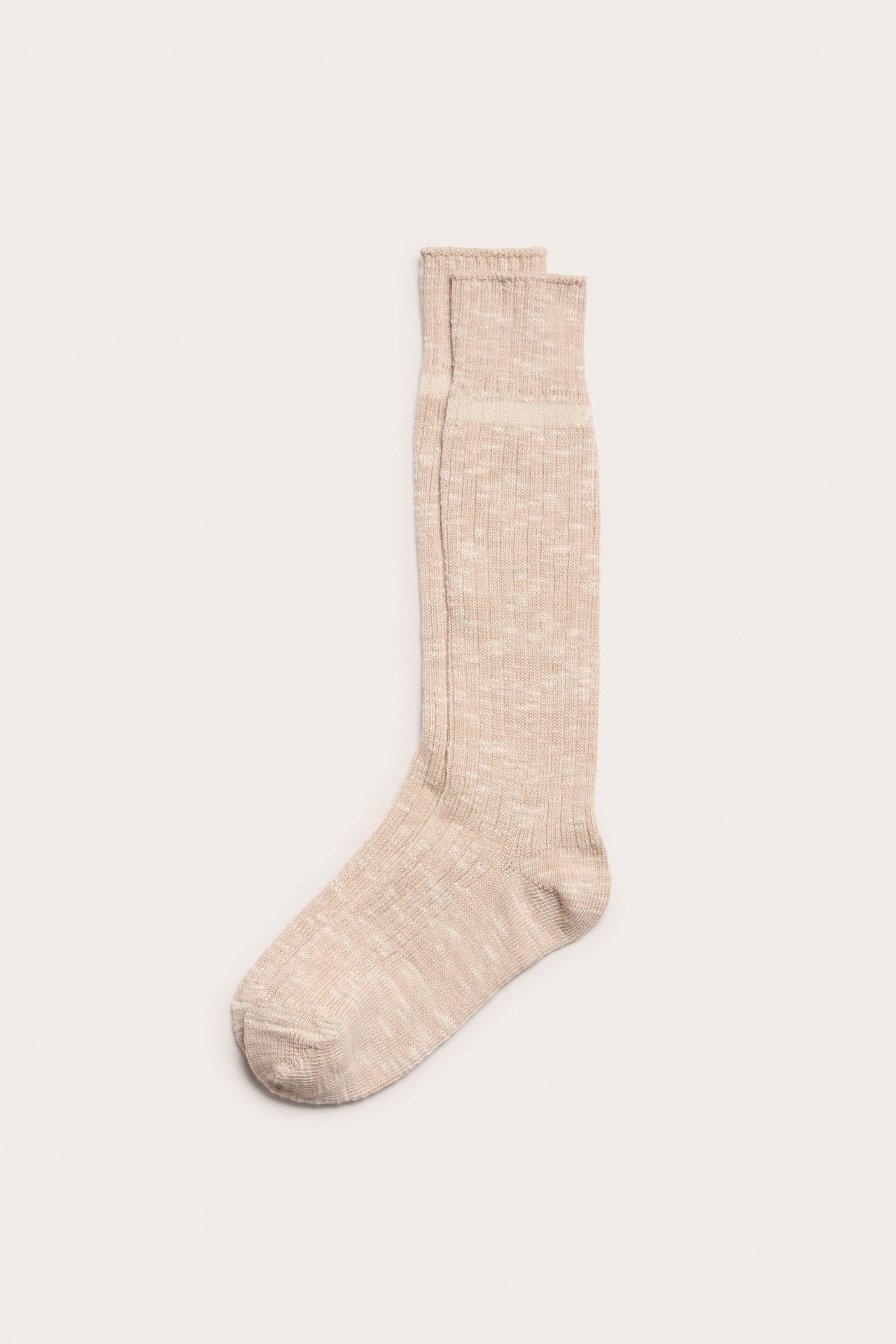 Platt bild av två ljusmelerade rosa ribbade strumpor.