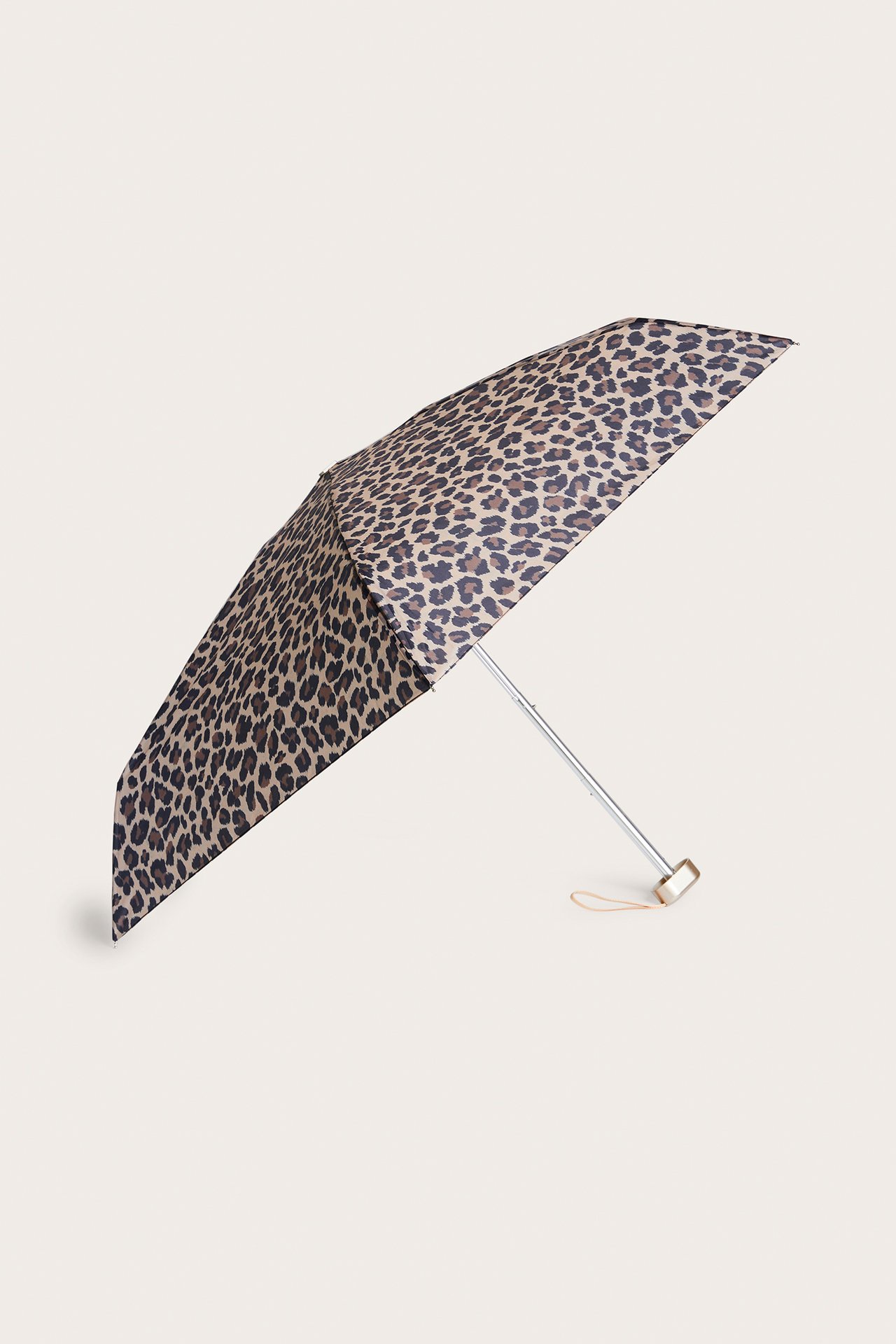 Vinklad vy av ett beige leopardmönstrat teleskopparaply i polyester med silverfärgat skaft och liten ögla.