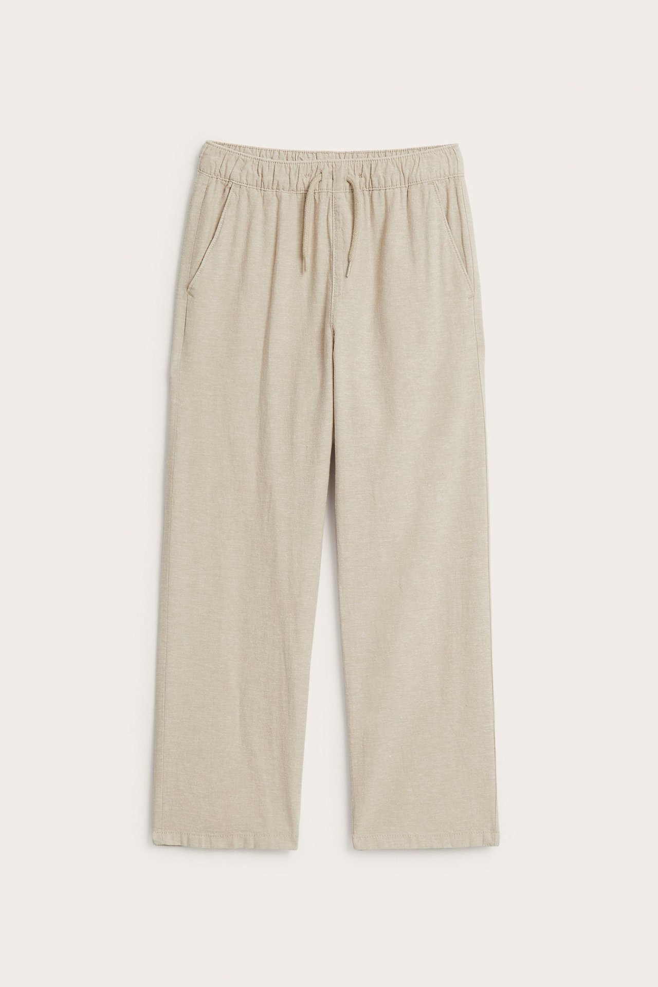 Widok z przodu beżowych spodni z mieszanki lnu z elastycznym pasem ze sznurkiem i kieszeniami.