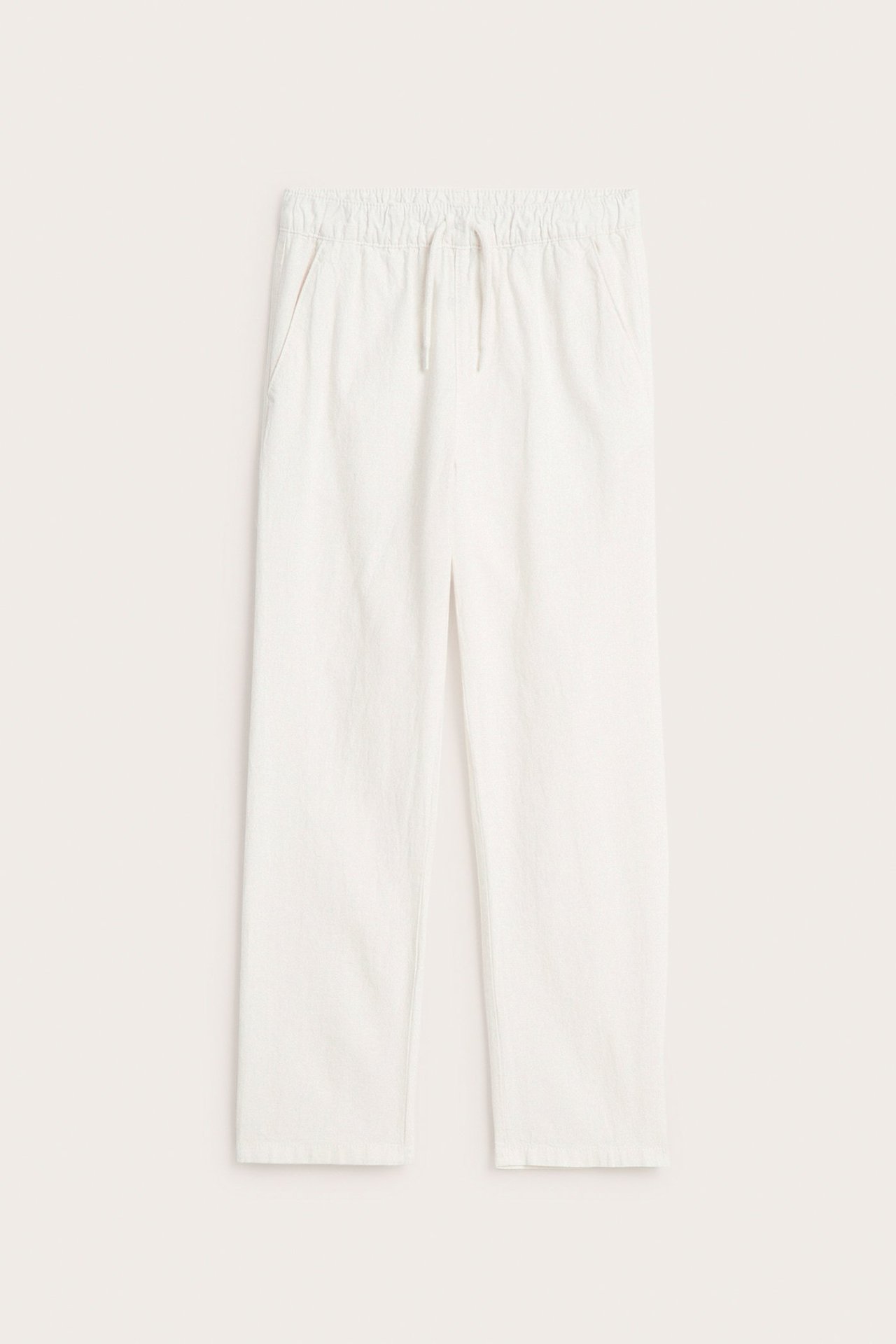 Widok z przodu: ecru spodnie z mieszanki lnu dla dzieci, z elastyczną talią, sznurkiem i bocznymi kieszeniami.
