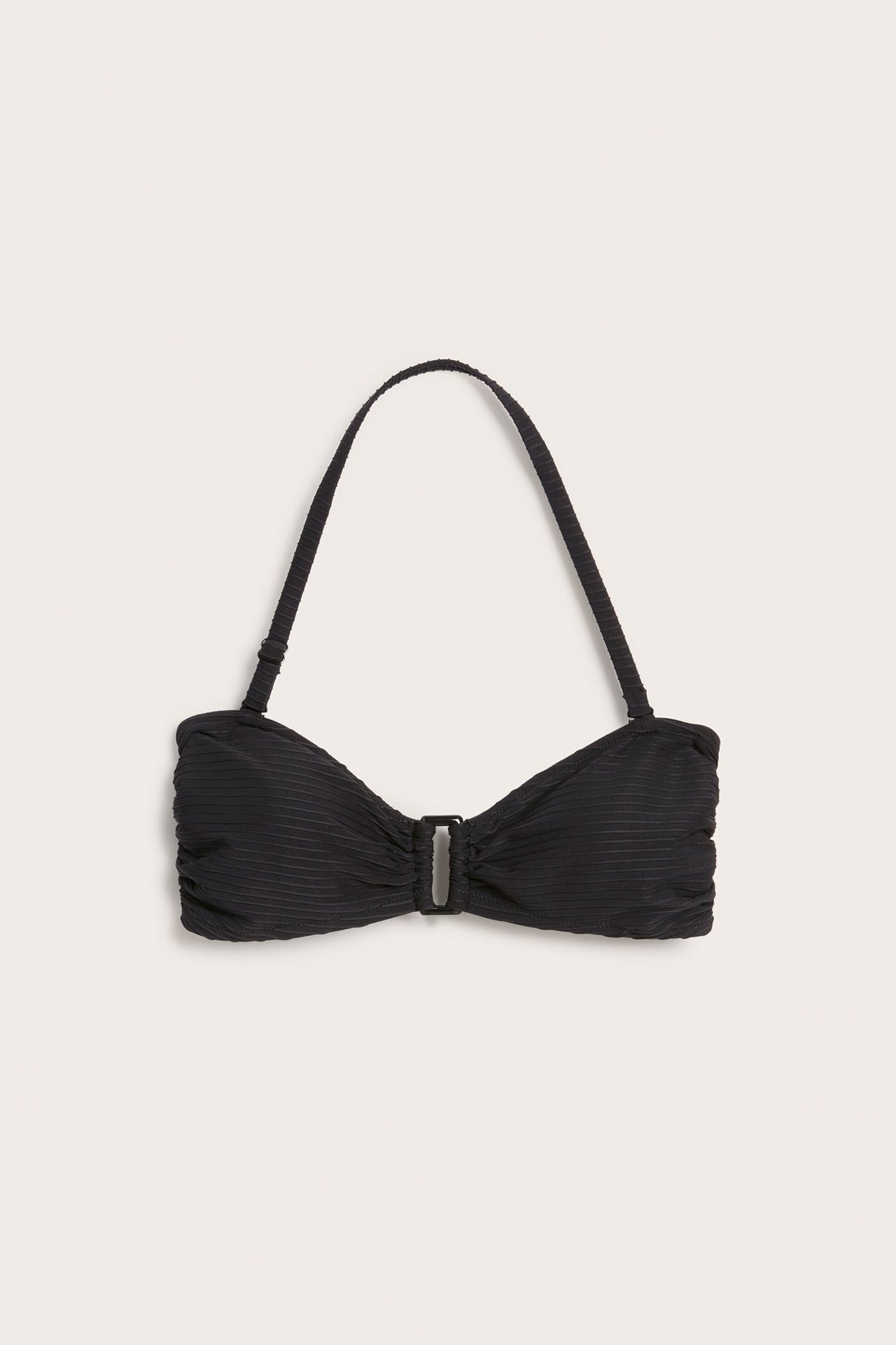 Widok z przodu czarnego, strukturalnego biustonosza bandeau z ozdobną klamrą i regulowanym ramiączkiem.