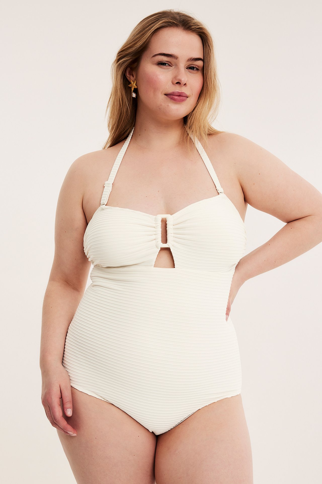 Frontvisning: kvinne i off-white strukturert bandeau badedrakt med dekorativ spenne.