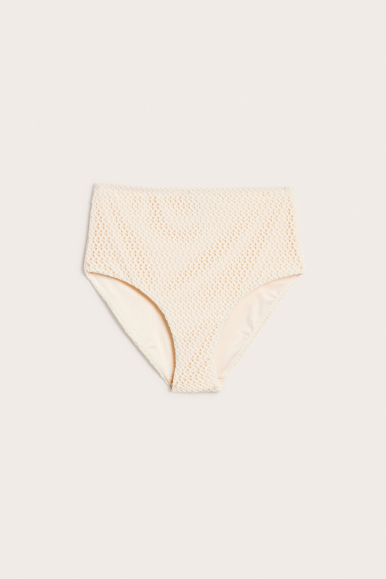 Framifrån, vita högmidjade bikinitrosor med virkad struktur.
