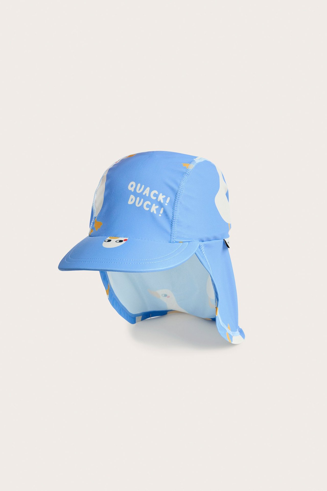 Edestä kuvattu lasten sininen UV-aurinkohattu ankkatulosteella, niskaläpällä ja tekstillä 'QUACK! DUCK! DUCK!'.