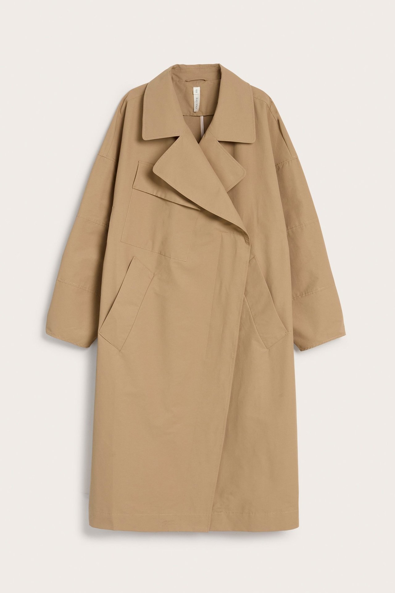Framifrån, beige trenchcoat i bomullsblandning med vida slag och stora fickor, i oversized passform.