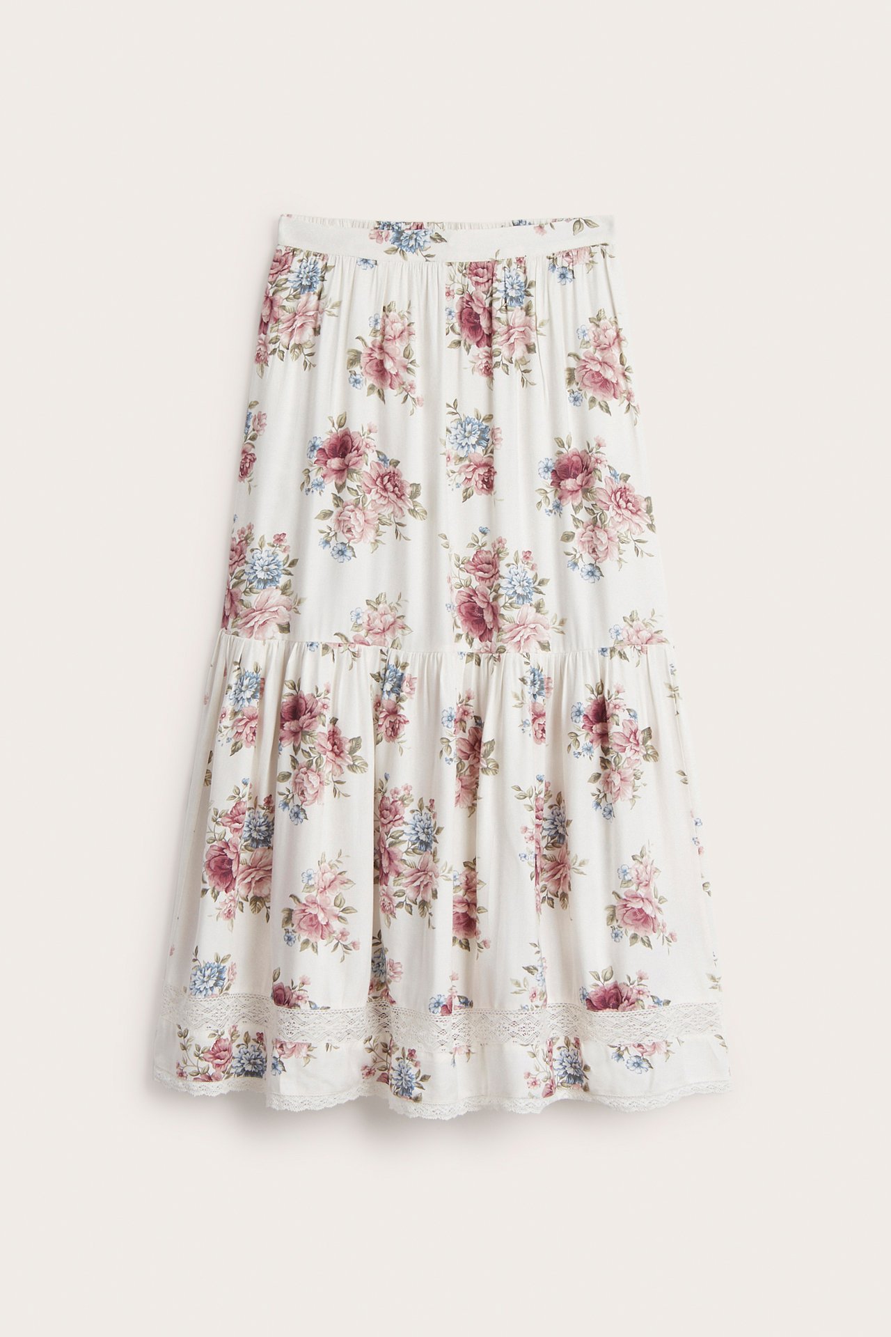 Framifrån, offwhite blommig maxikjol i viskos twill med resår i midjan och spetsdetaljer.