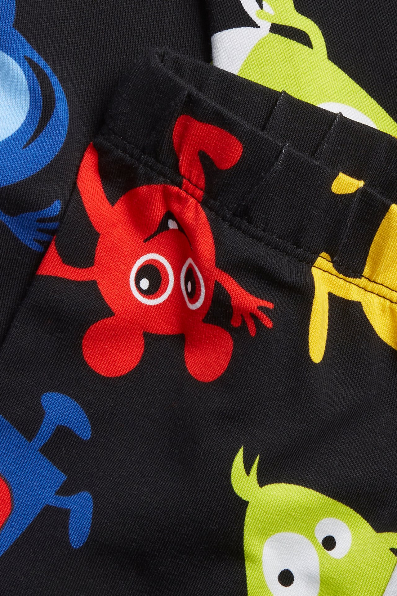 Zbliżenie na czarne legginsy niemowlęce z kolorowym wzorem Babblarna i elastycznym pasem.