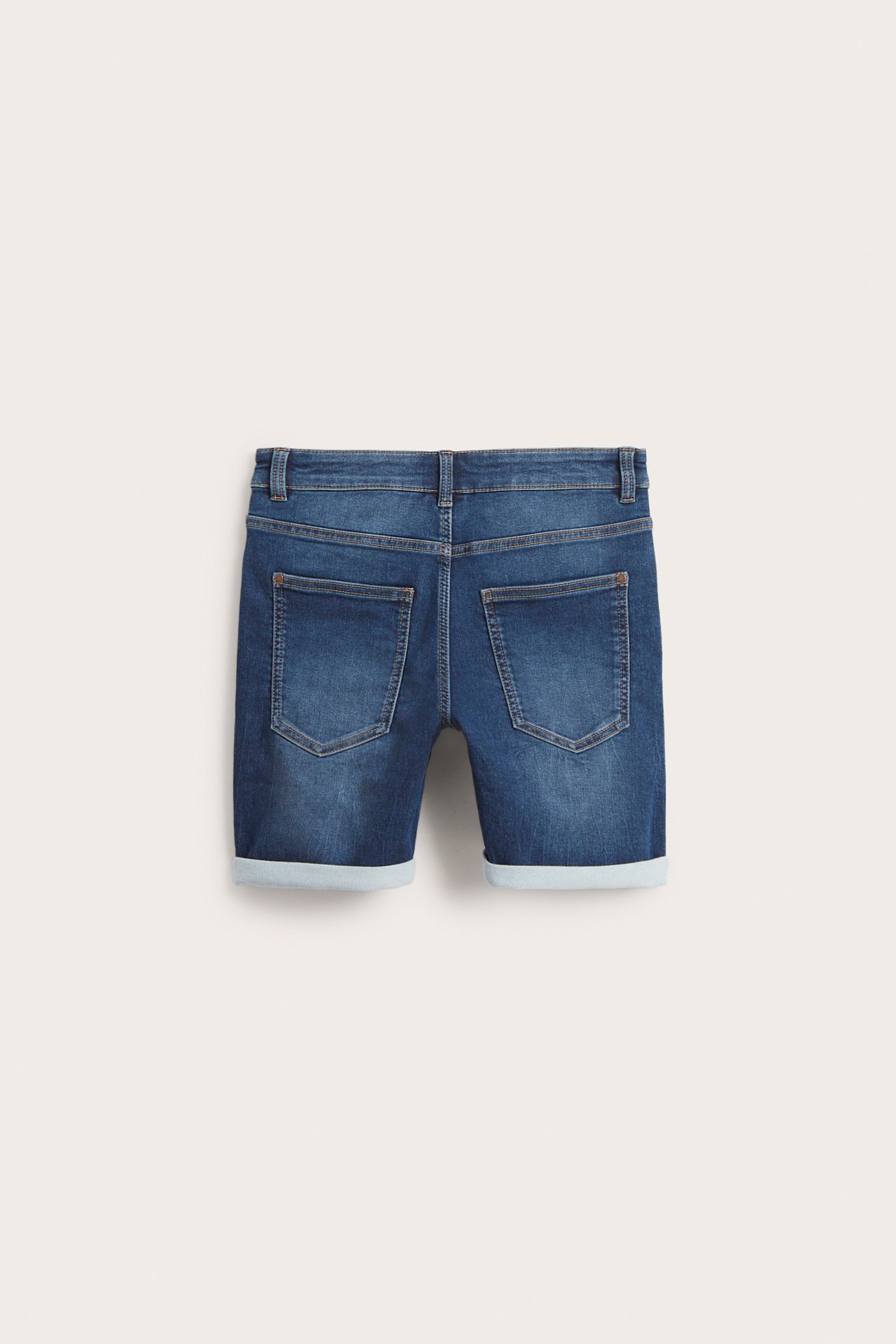 Bakifrån av mörkblå joggerjeansshorts för barn med två bakfickor och uppvikta benslut.