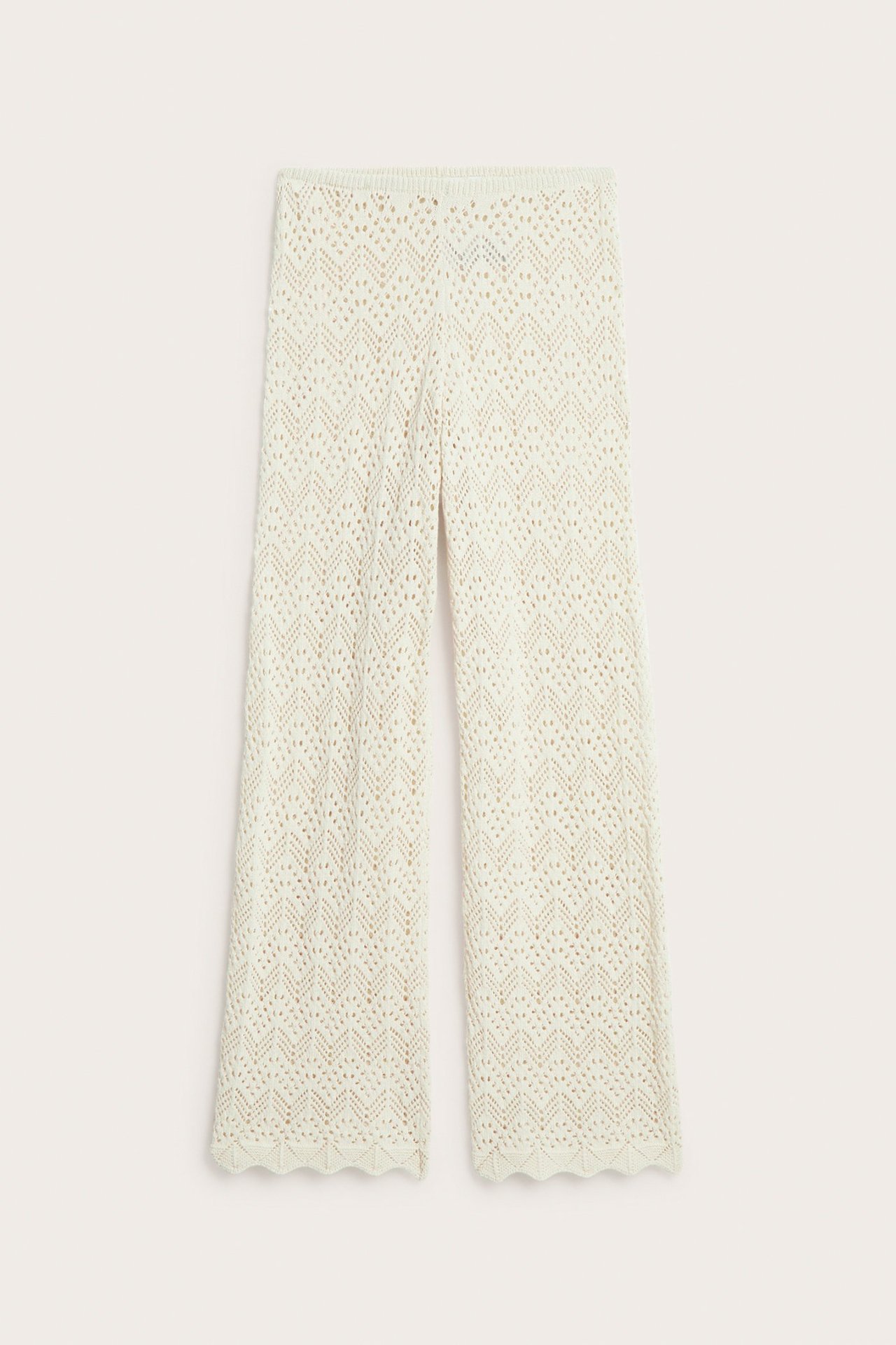 Edestä kuvatut vaaleanbeiget neulotut virkatut leveälahkeiset housut joustovyötäröllä ja aaltoreunalla.