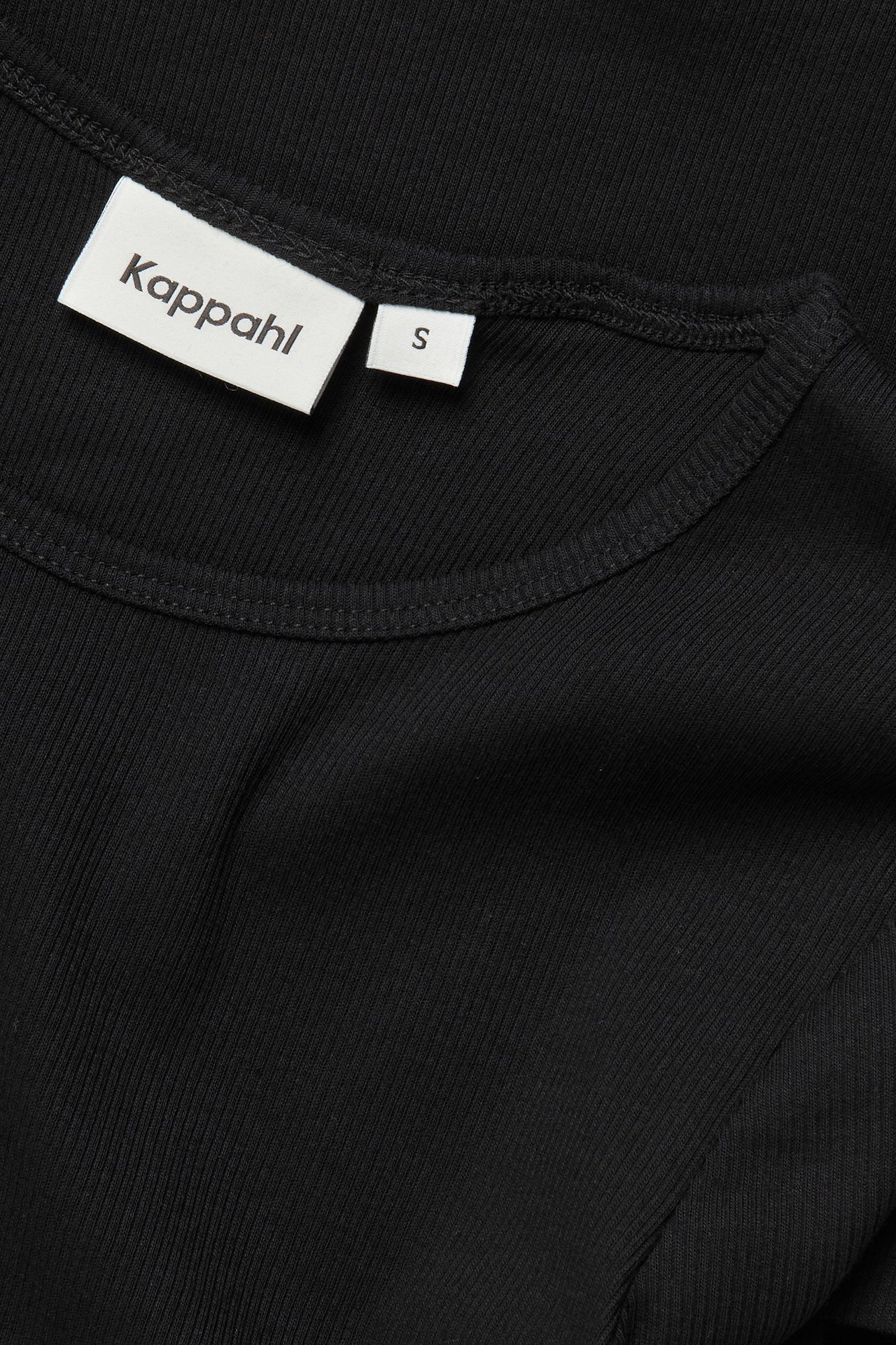 Zbliżenie czarnego, prążkowanego, dopasowanego t-shirtu z krótkim rękawem i okrągłym dekoltem.