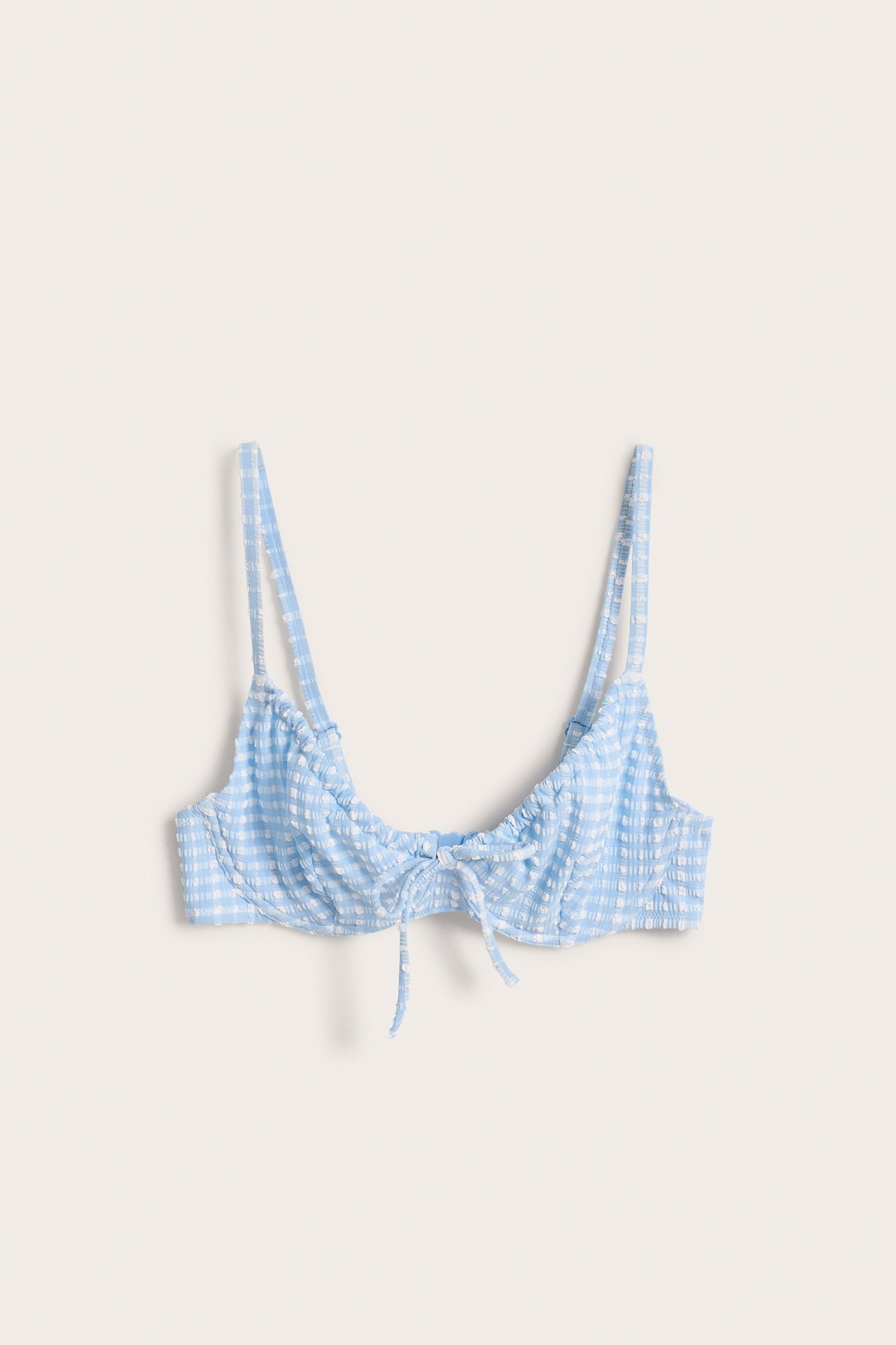 Framifrån, ljusblå och vitrutig bikini-bh med bygel, rynkade kupor och knyt framtill.