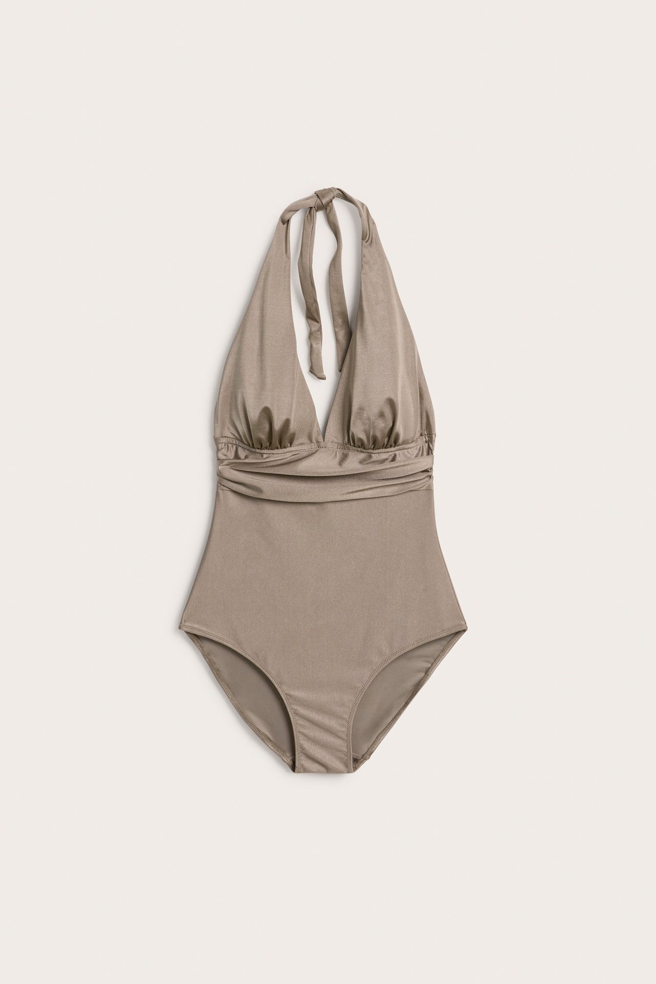 Framifrån: mörkbeige glansig halterneckbaddräkt med rynkade detaljer.
