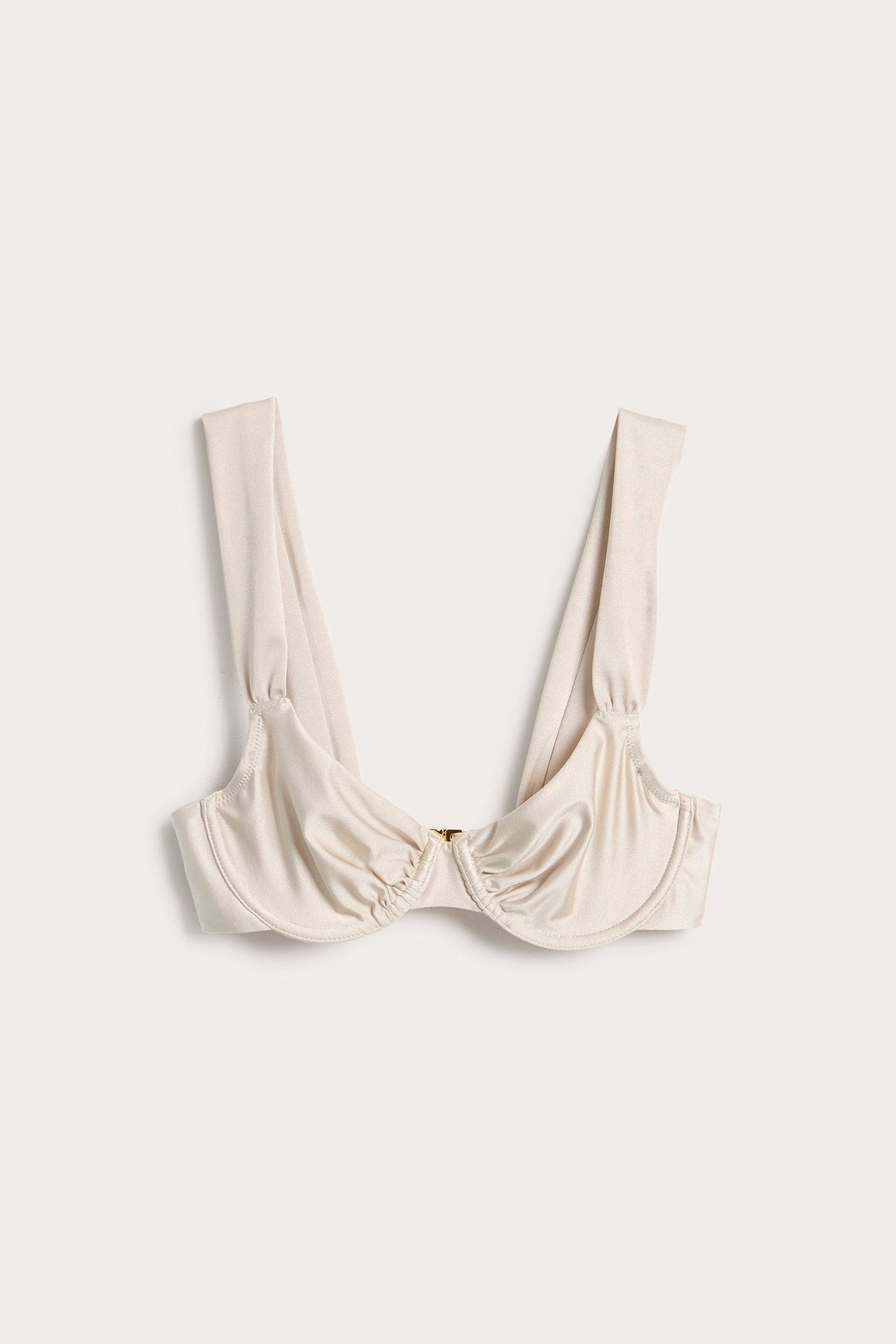 Frontvisning av en beige bøyle-bikinitopp med draperte cuper, brede stropper og liten gullfarget frontspenne.