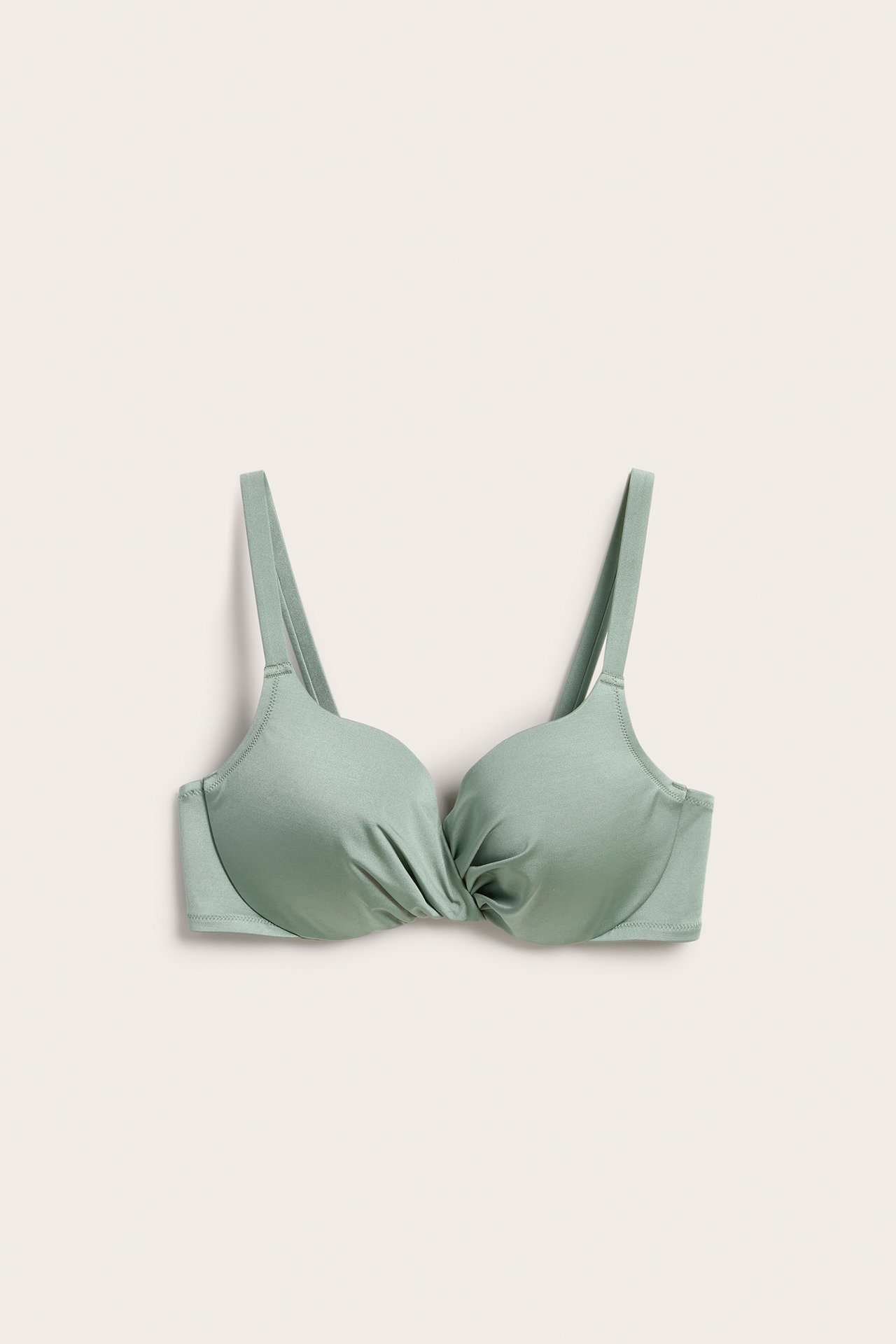 Framifrån, ljusgrön bikini-bh med vadderade bygelkupor och rynkad omlottdetalj framtill.