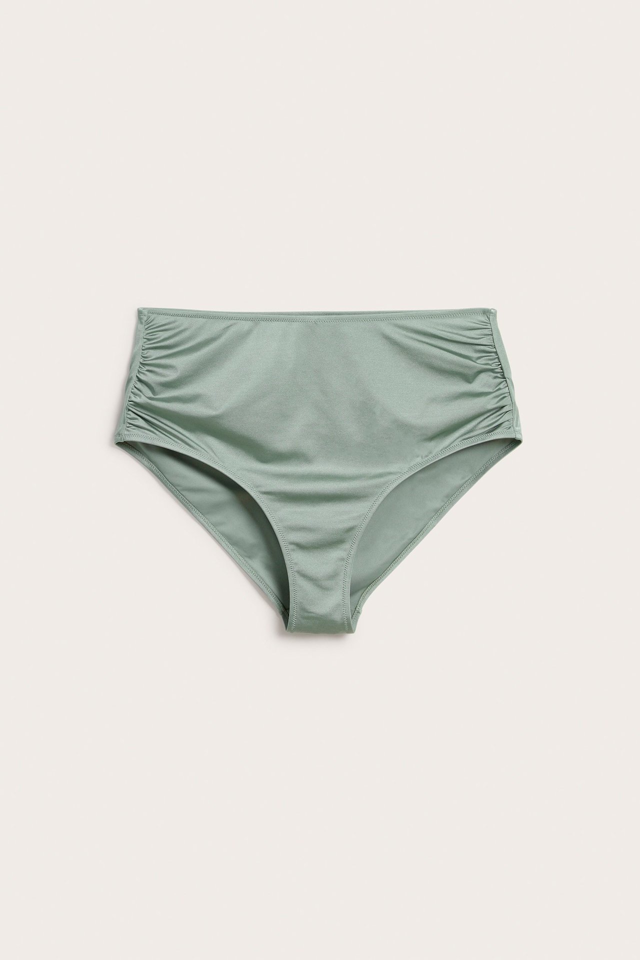 Frontvisning av en lysegrønn høy midje bikinitruse med rynker på sidene.