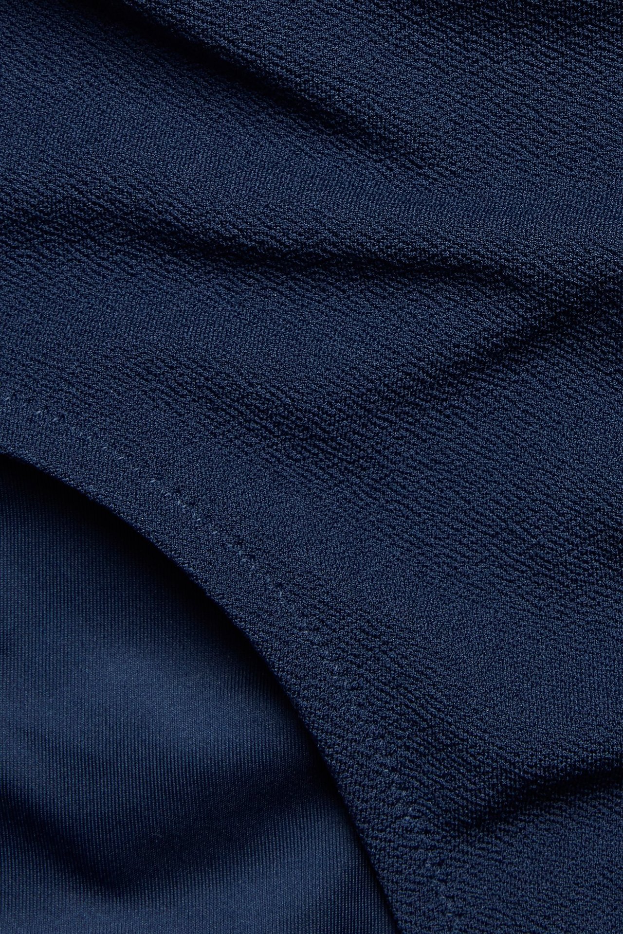 Zbliżenie na granatowe figi kąpielowe typu hipster z krepowaną fakturą.