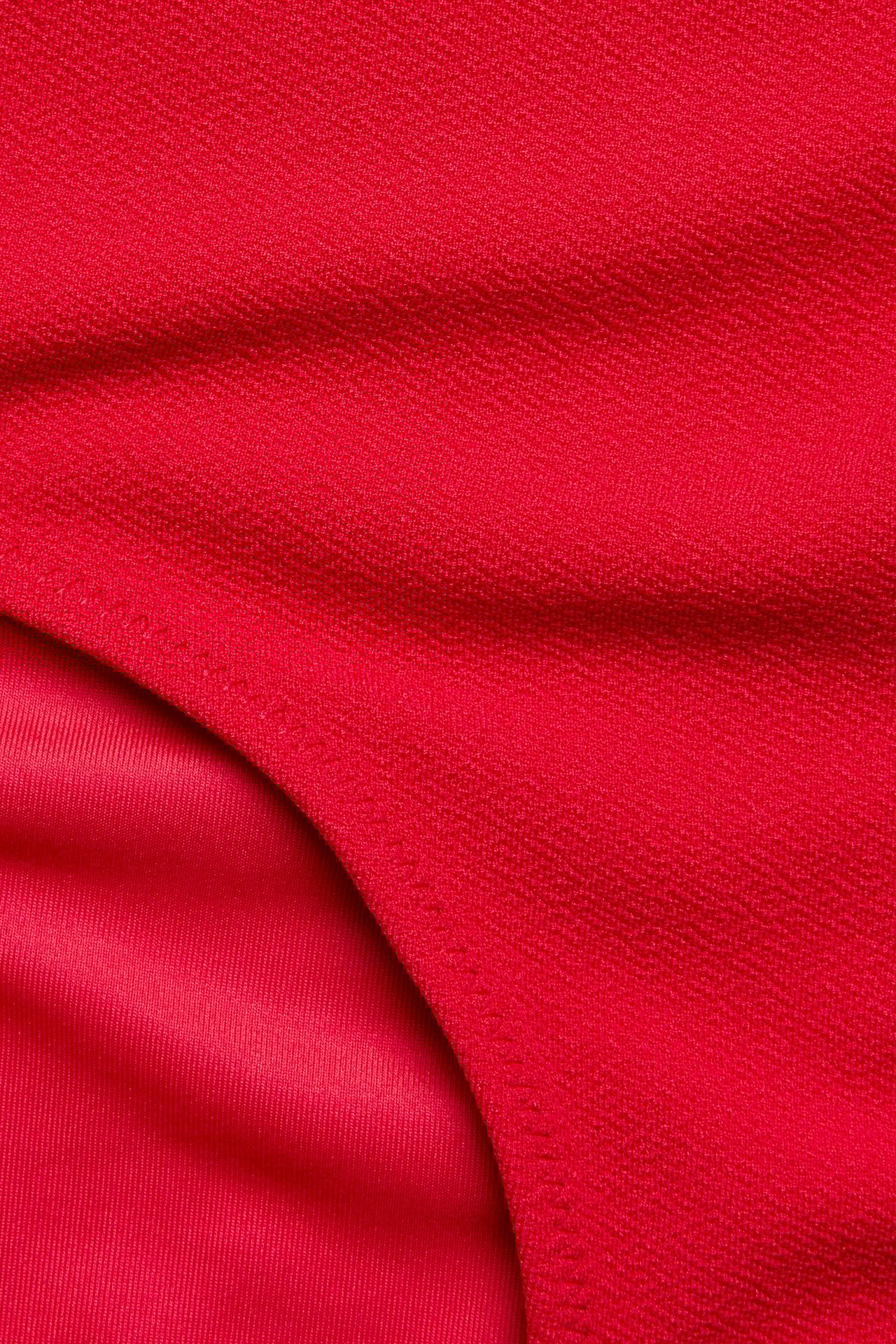 Zbliżenie czerwonych, marszczonych majtek kąpielowych typu hipster o teksturowanej powierzchni.