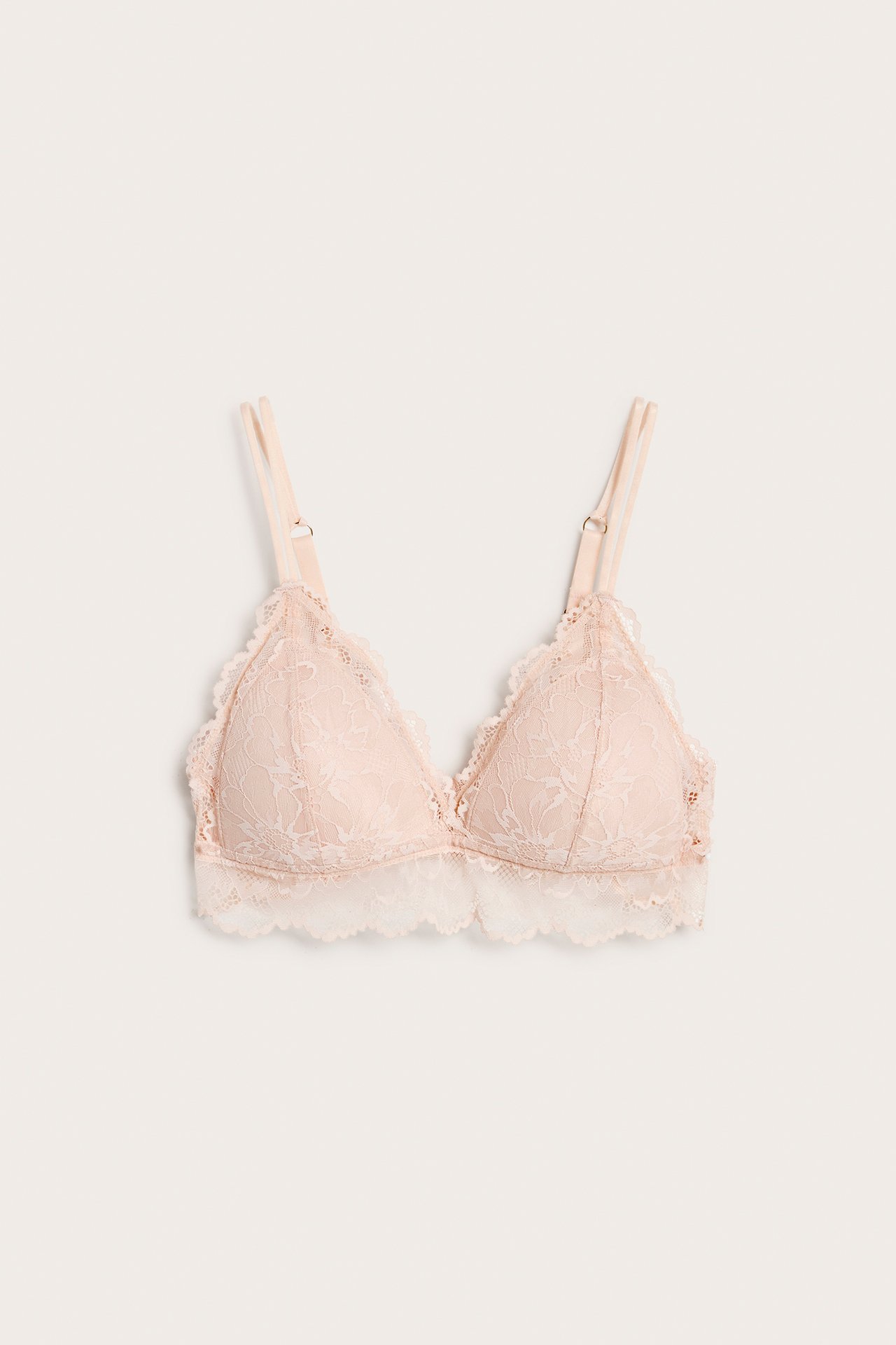Framifrån, ljusrosa spetsbralette med vaddering och smala dubbla justerbara axelband.