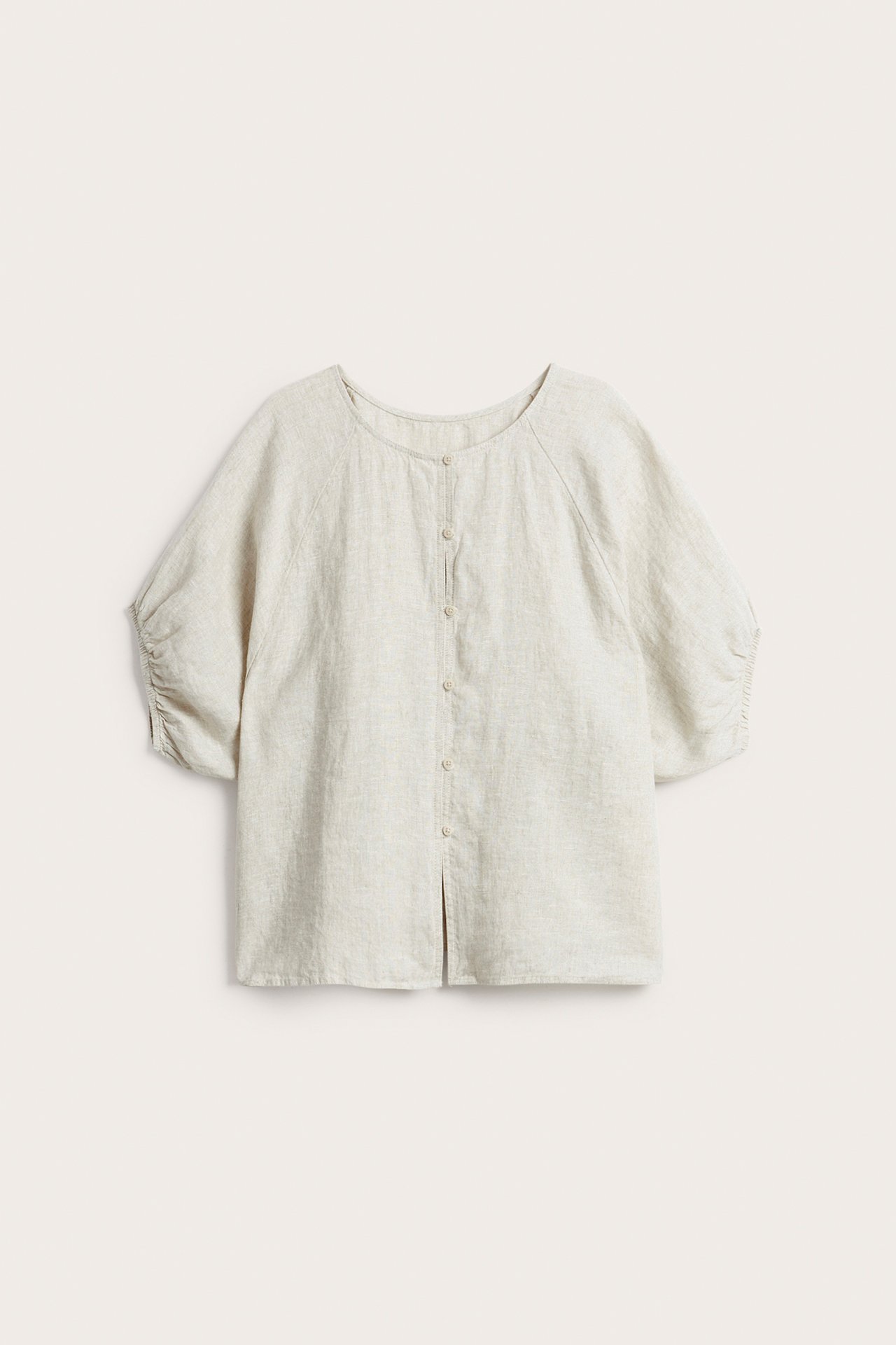 Framifrån: Beige linneblus med rund hals, knäppning och halvlånga ärmar med resår i ärmslut.