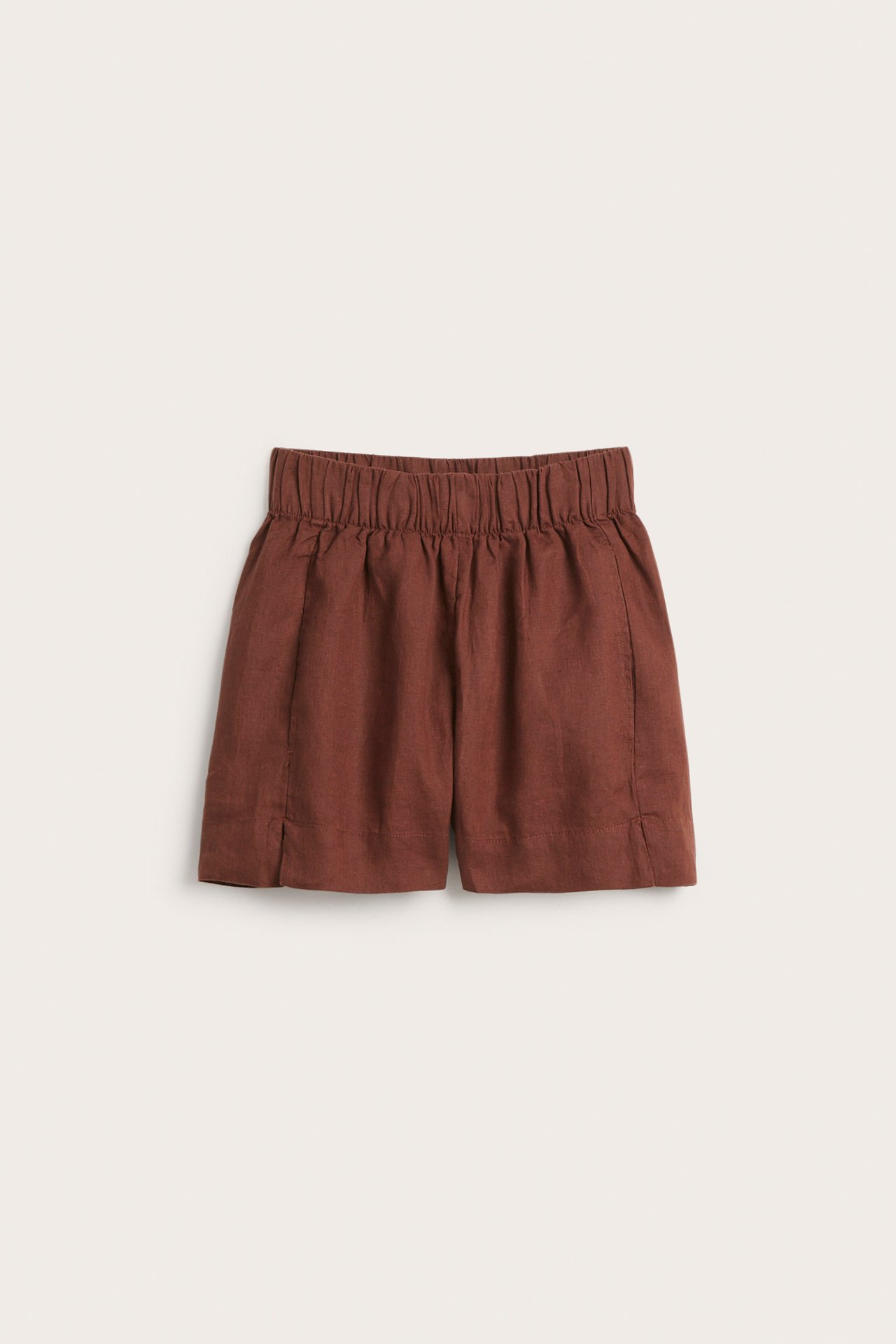Framifrån: bruna linneshorts med resår i midjan och sidfickor.