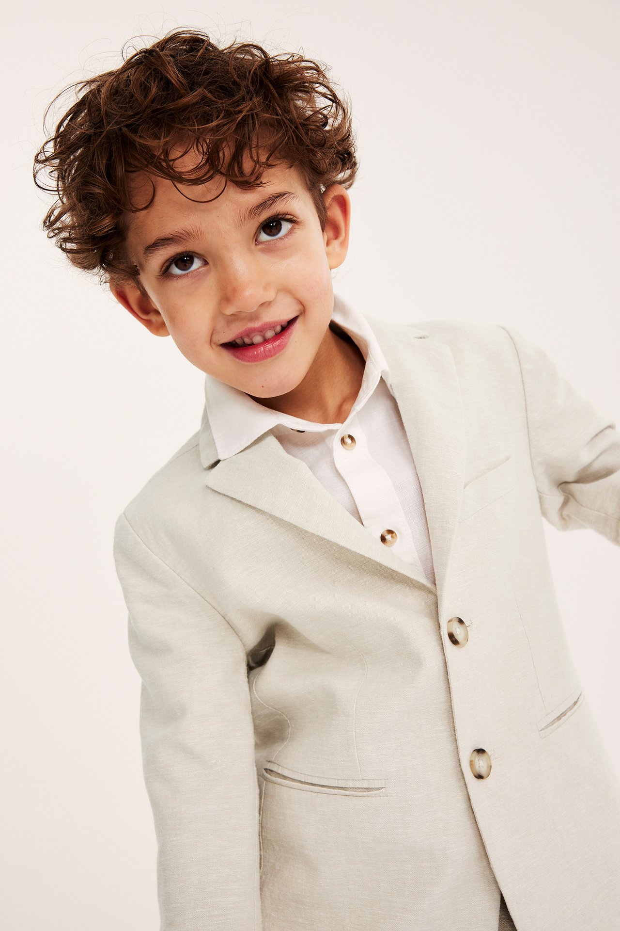 Forfra: Barn i lys beige linblanding blazer med to knapper over en hvit skjorte.