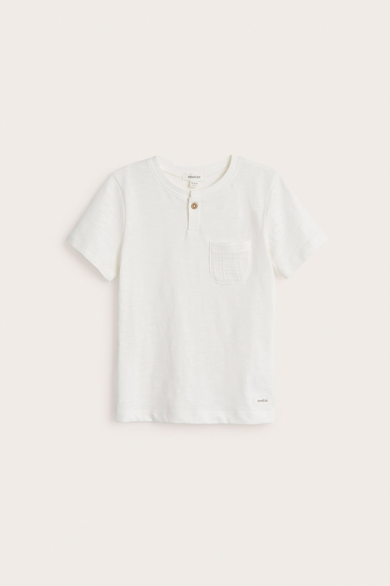 Widok z przodu: Ecru dziecięcy t-shirt z dżerseju slub, krótkimi rękawami, guzikiem i kieszonką.
