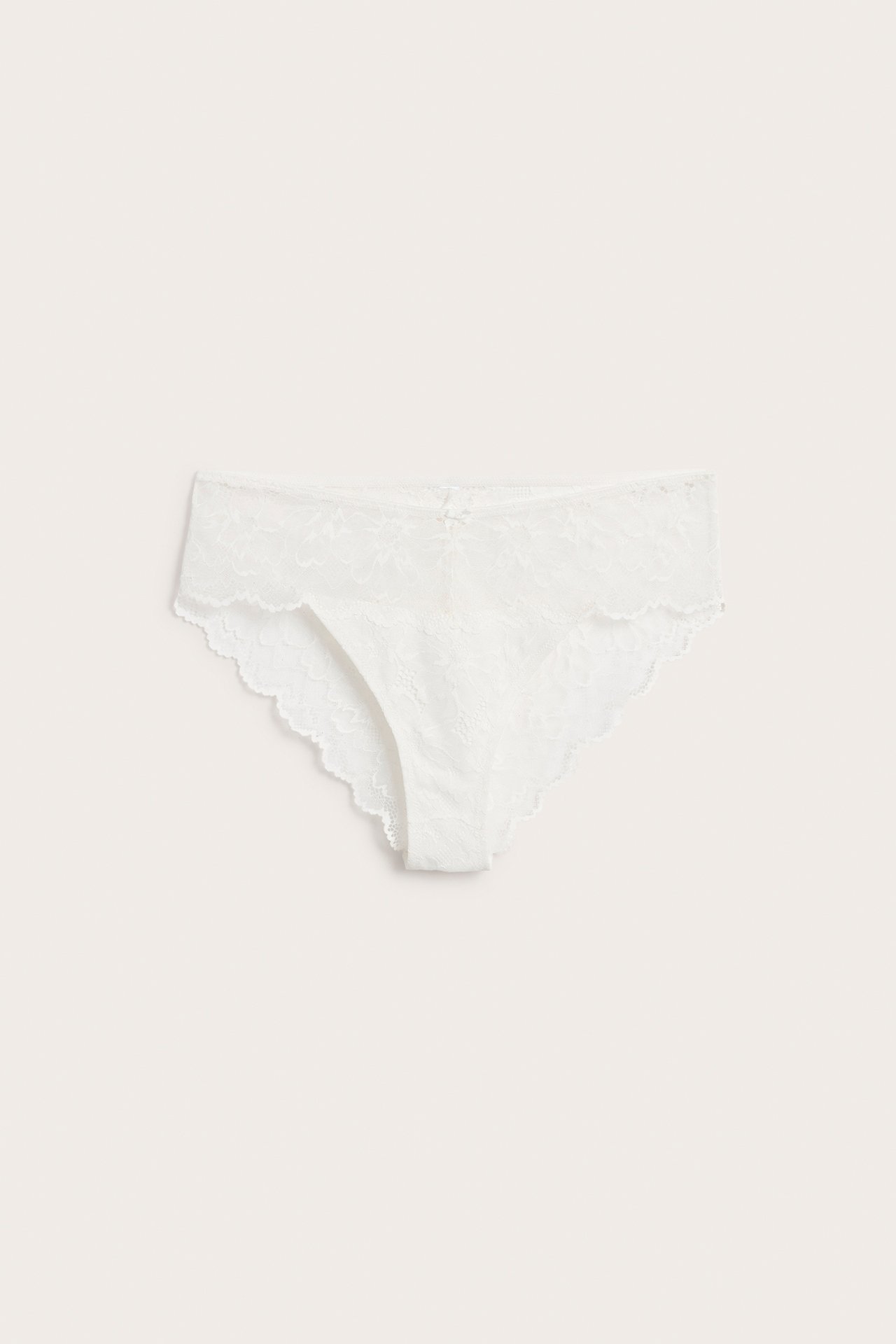 Framifrån, vita spets brazilian trosa för dam med liten rosett framtill.