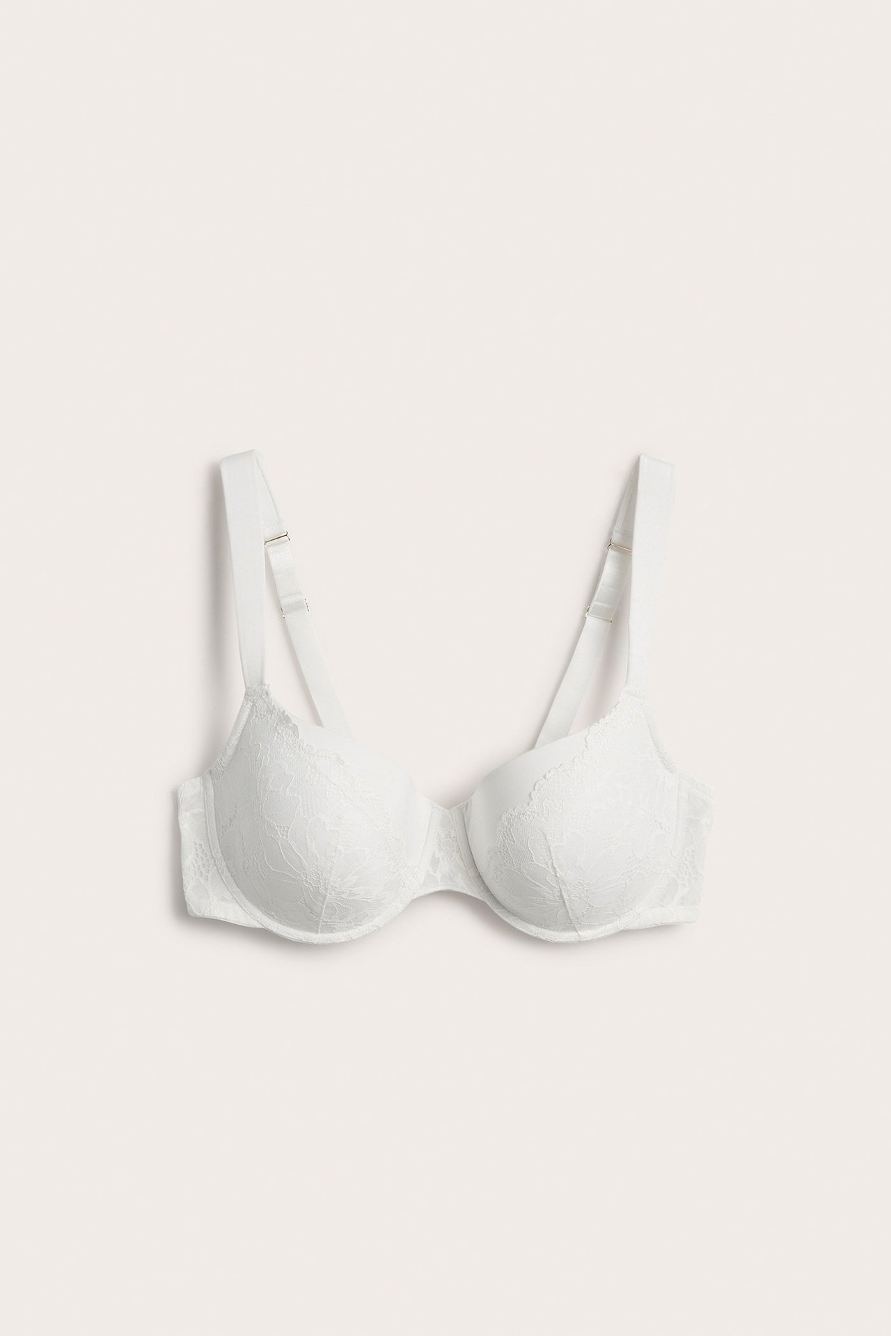 Forfra, hvit vattert bøyle-BH med blondemønster og brede stropper.