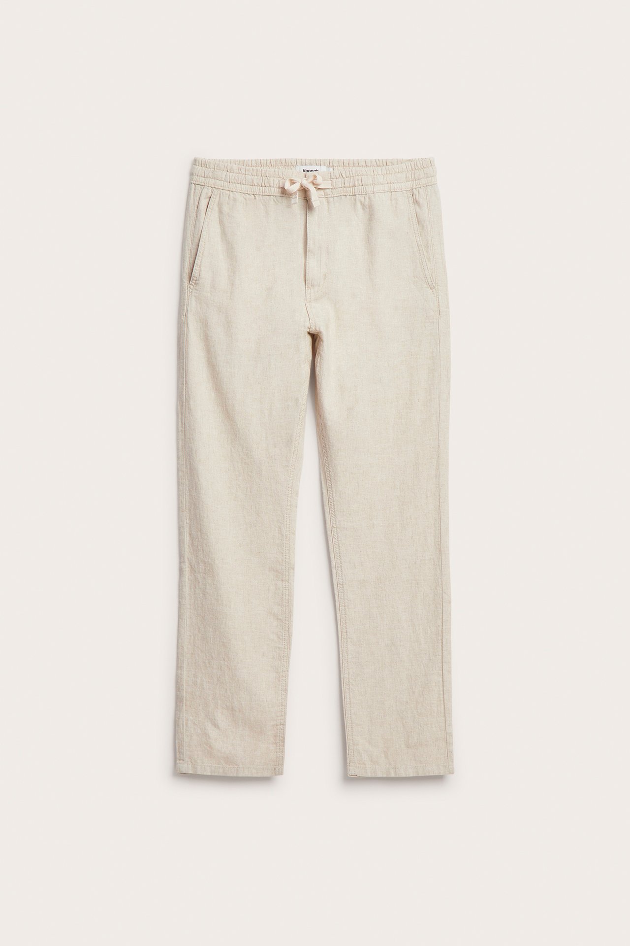Frontvisning av beige linblandingbukser med elastisk snøring i midjen og sidelommer.