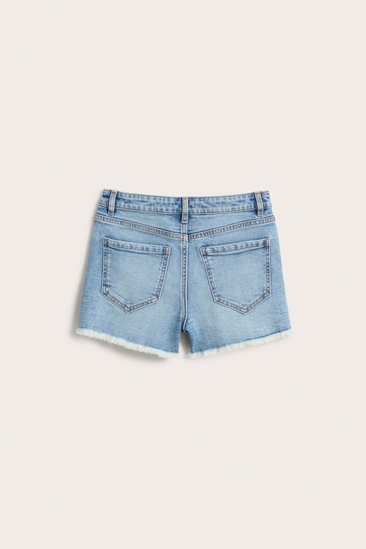 Bakifrån av ljusa denimshorts för barn med råa, fransiga benslut och bakfickor.