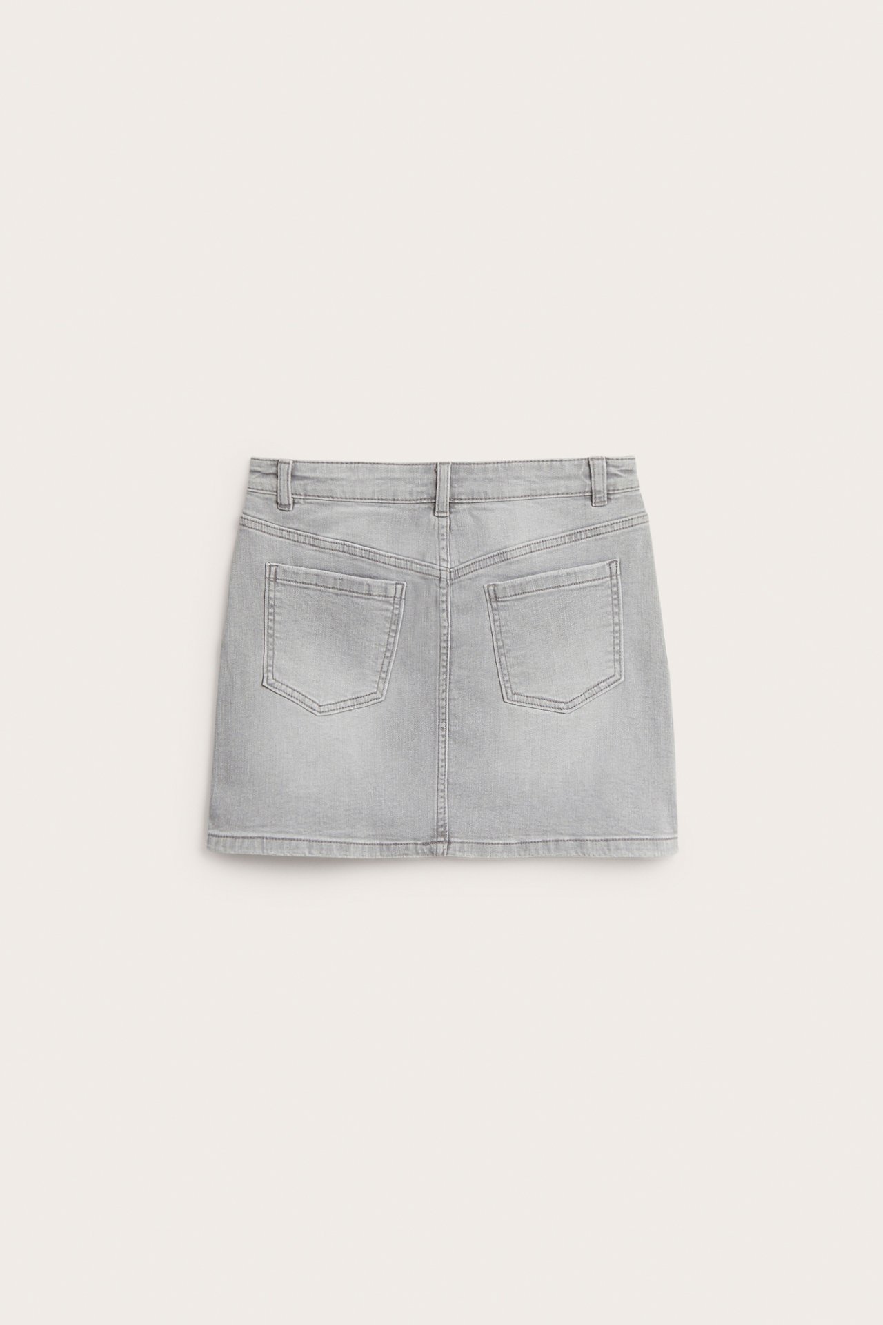 Bakifrån av en kort grå stretch-jeanskjol med två bakfickor.