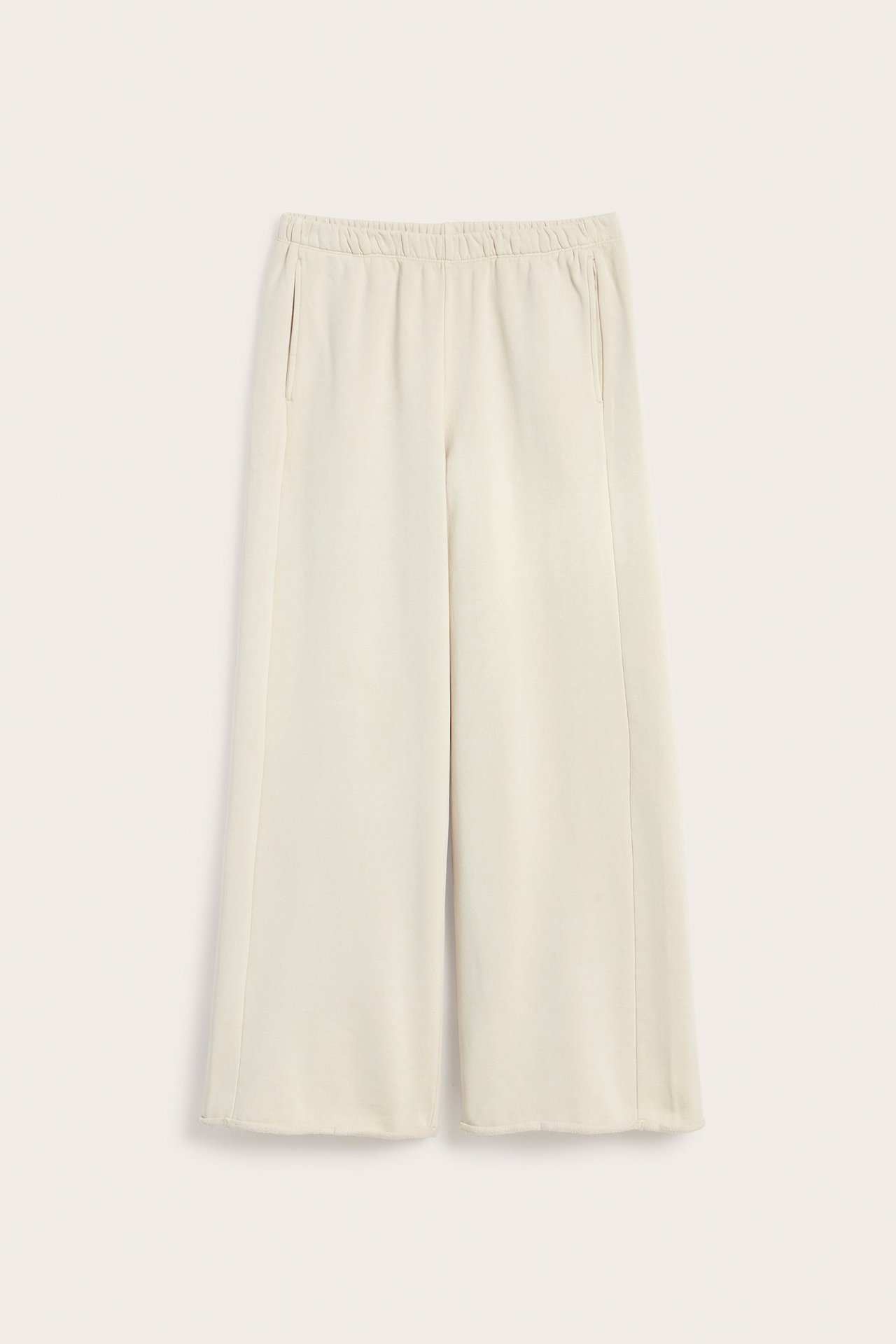 Frontvisning av lysebeige rette jerseyjoggebukser med elastisk midje og sidelommer.