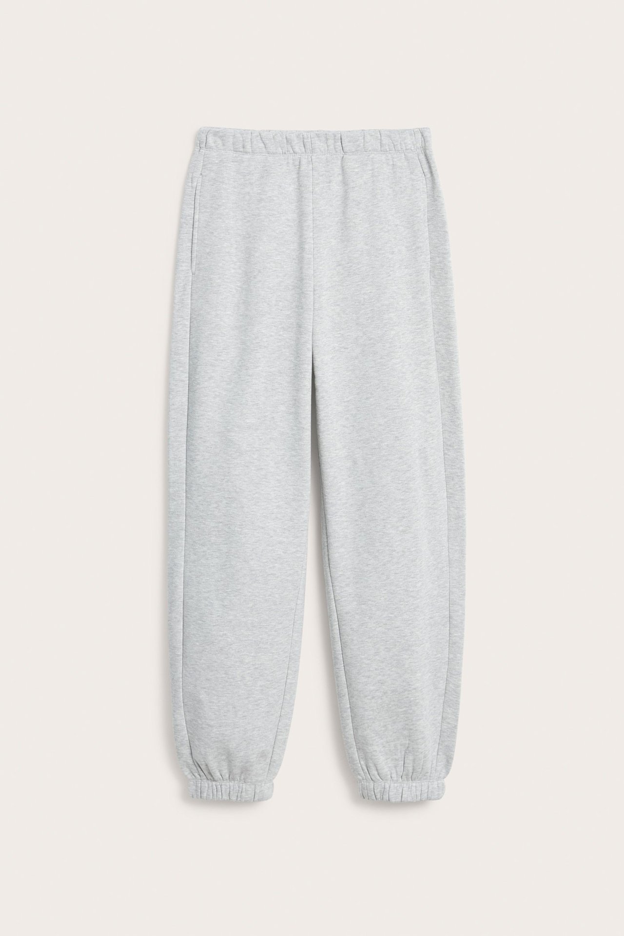 Frontvisning av gråmelert loungewear-joggebukse med elastisk midje, sidelommer og mansjetter.