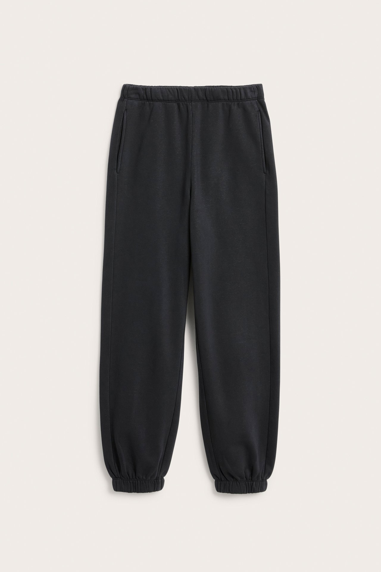 Frontvisning av svarte loungewear-joggebukser med elastisk midje, sidelommer og elastiske mansjetter.