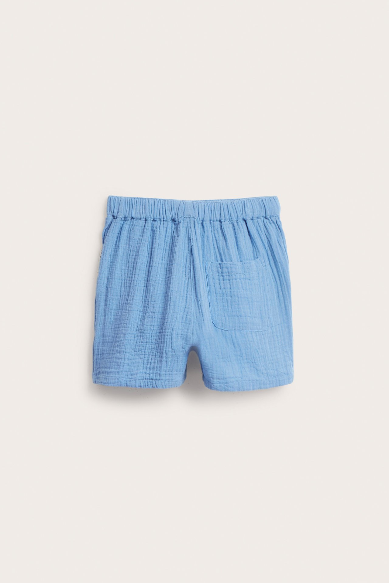 Bakifrån: blå muslinshorts med resår i midjan och en bakficka.