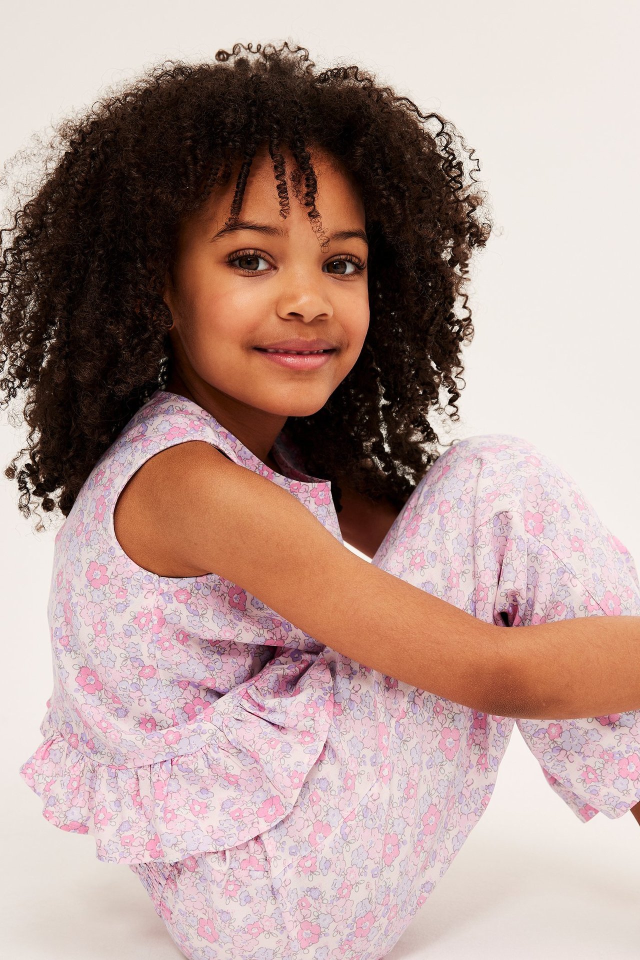 Frontvy av ett barn i rosa blommiga culottebyxor i viskos och matchande ärmlös topp.