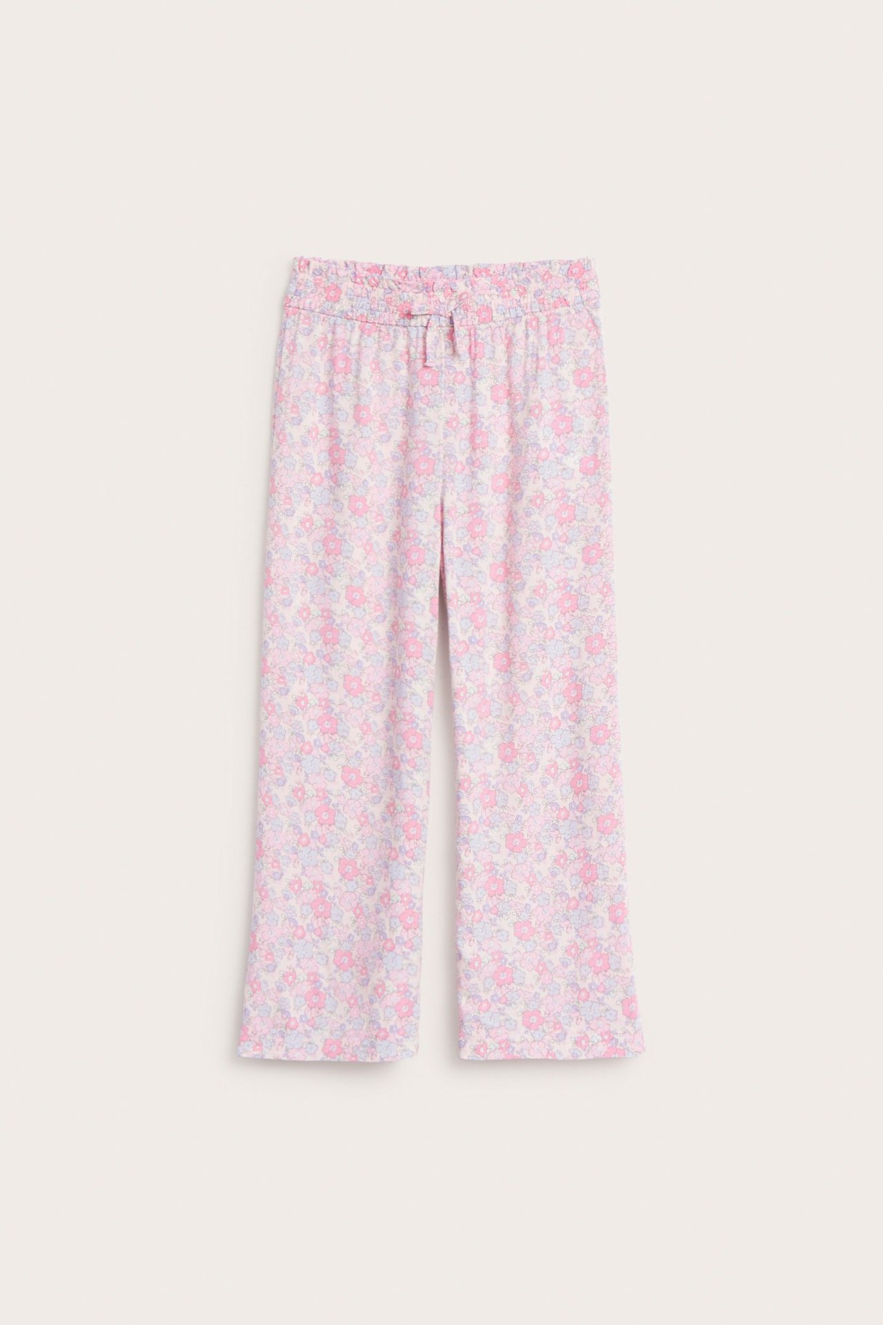 Frontvy av rosa blommiga drapåbyxor i mjuk vävd viskos med resår i midjan.