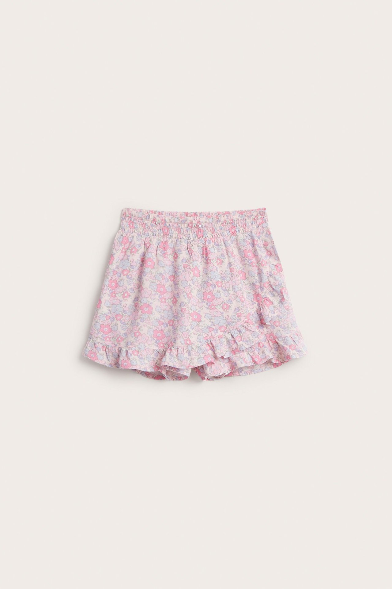 Widok z przodu różowych, kwiecistych szortów/spódniczki z wiskozy dla dziecka, z elastyczną talią i falbanką.